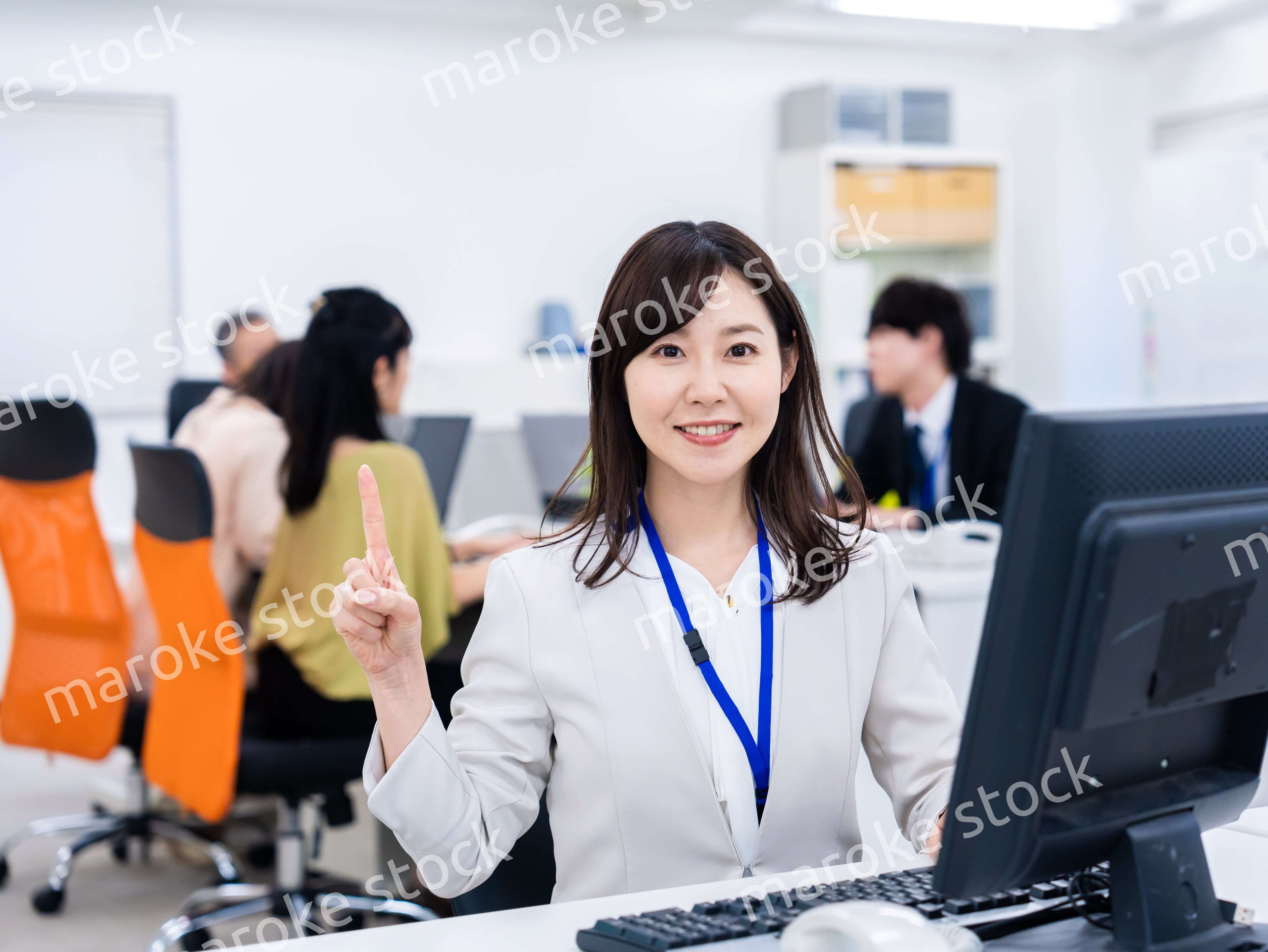 笑顔でポイントを指すビジネスウーマン