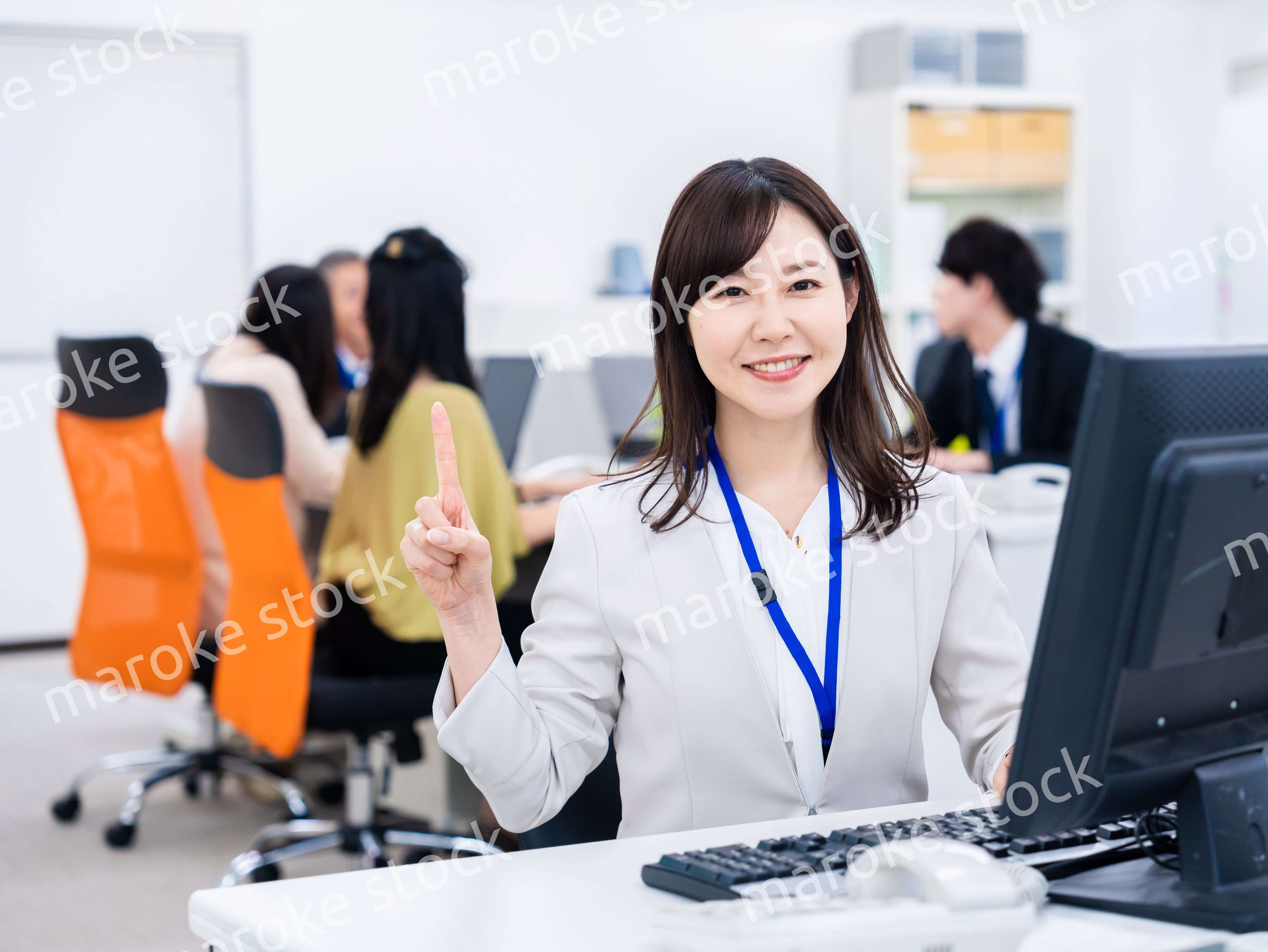 笑顔でポイントを指すビジネスウーマン