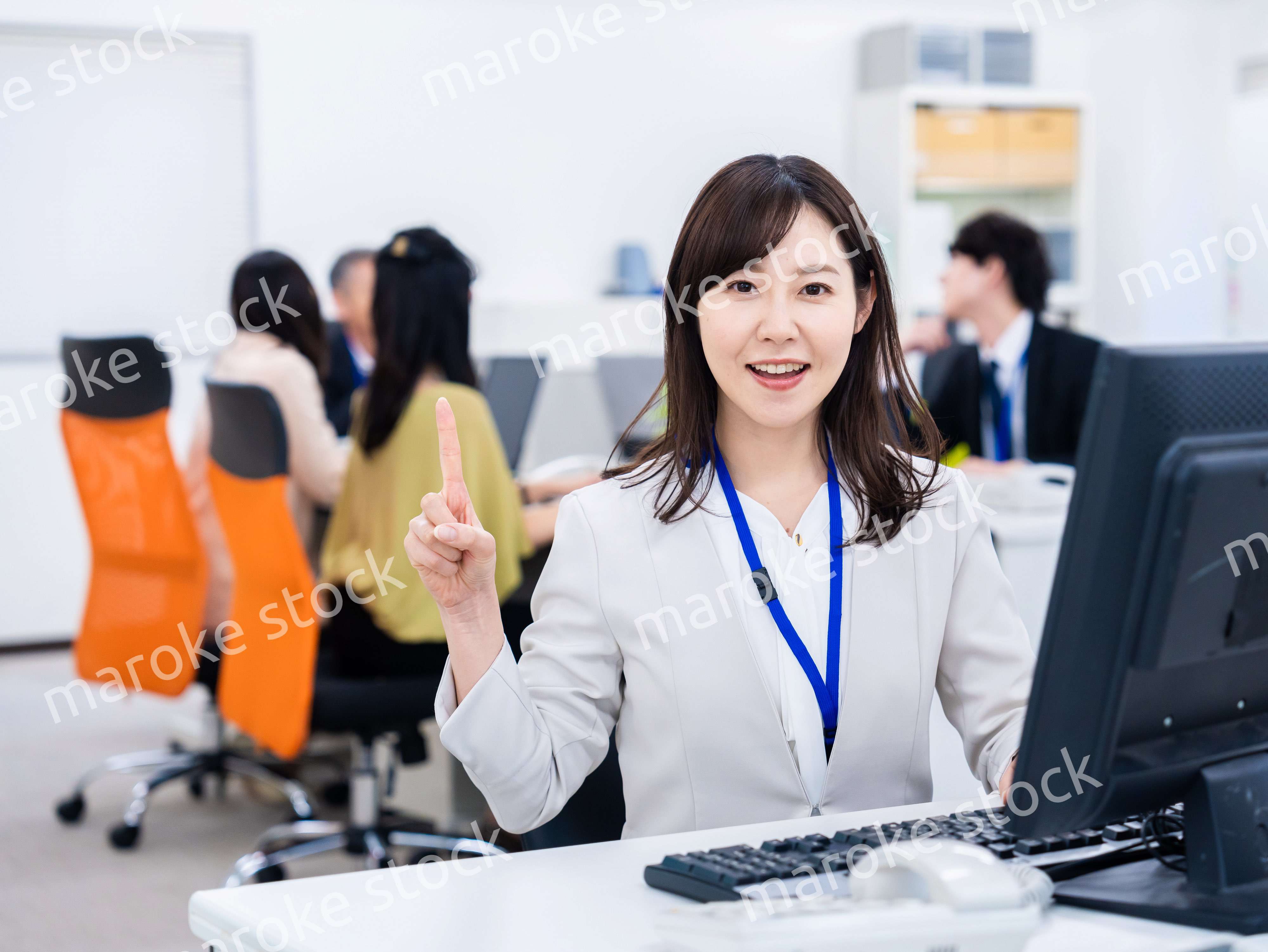 笑顔でポイントを指すビジネスウーマン