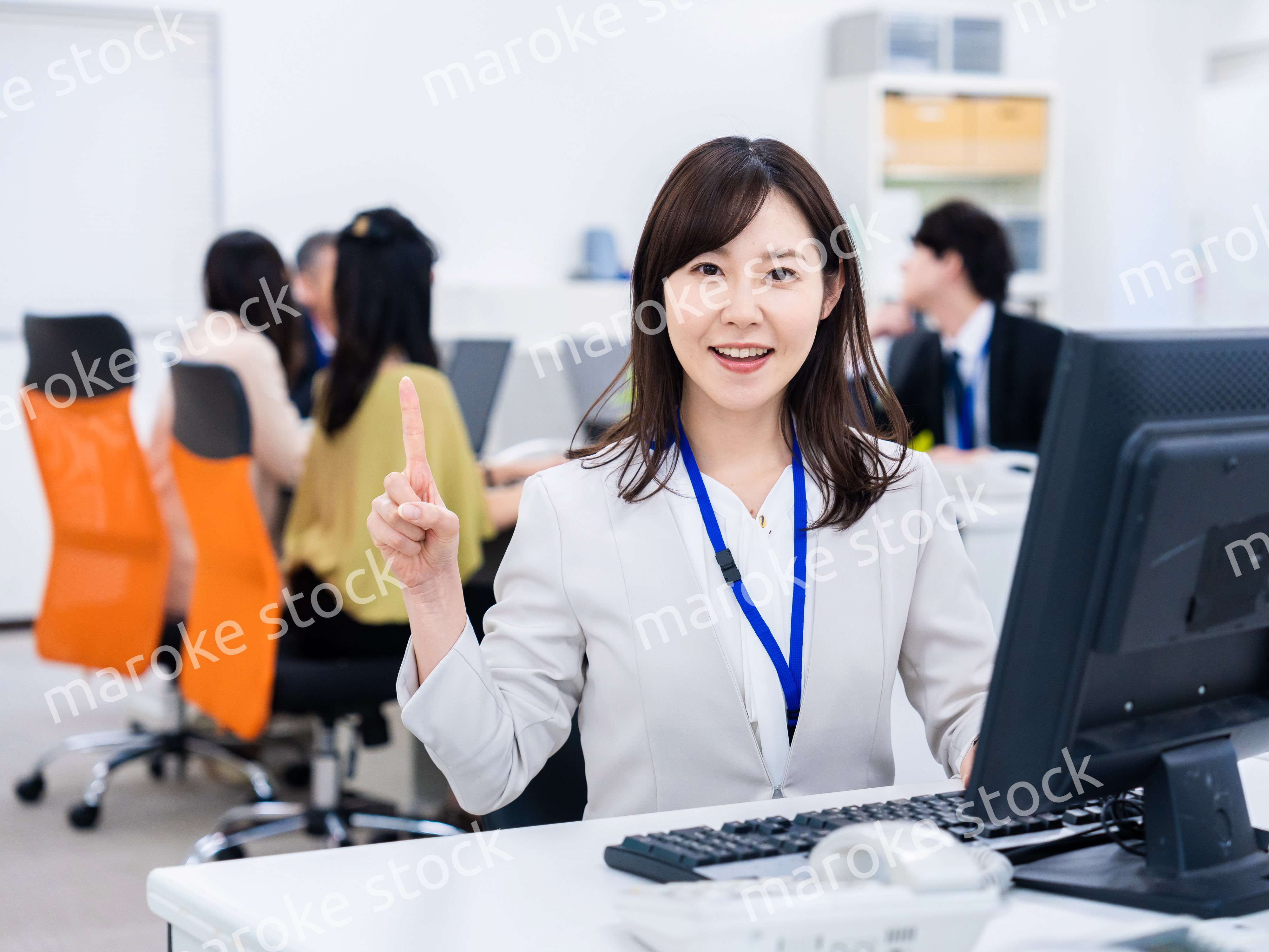 笑顔でポイントを指すビジネスウーマン