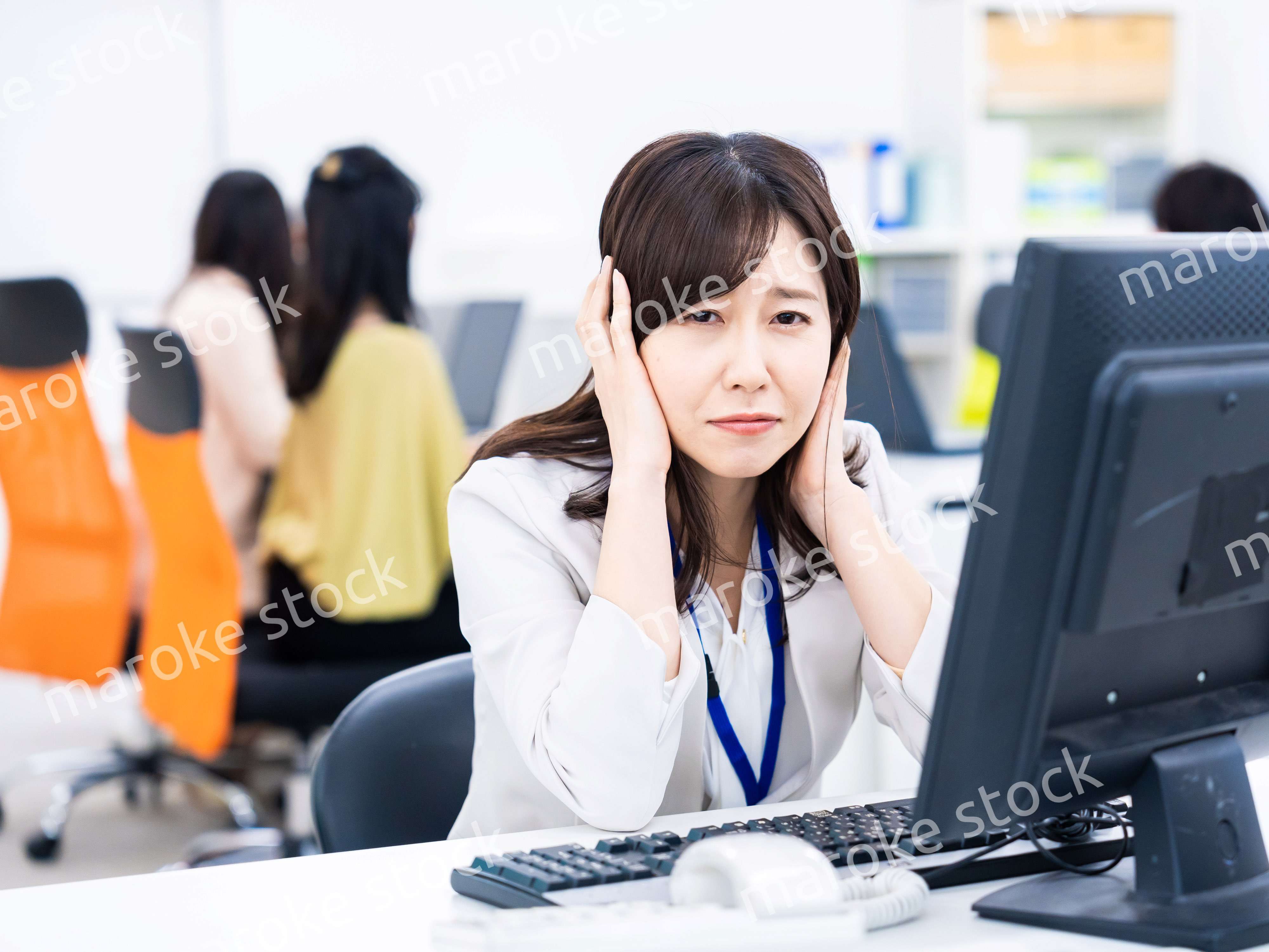 デスクワークをしながら頭を抱えるビジネスウーマン