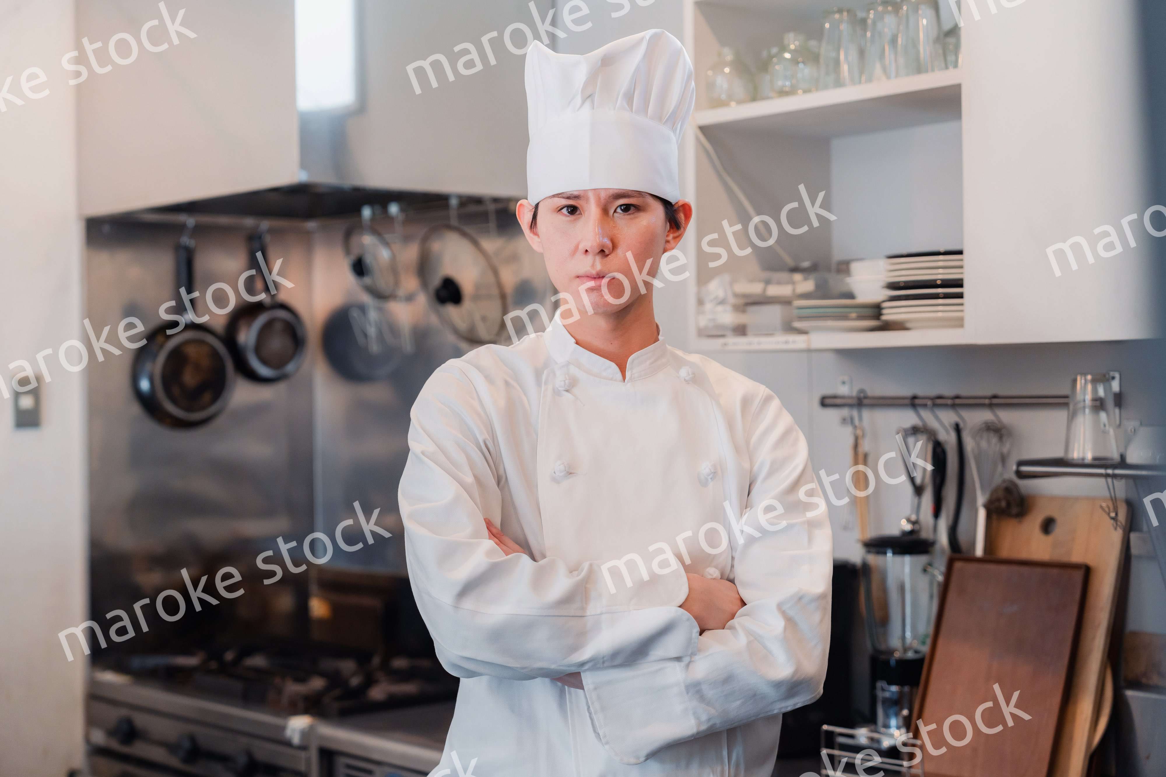 真剣な表情で腕組をする料理人