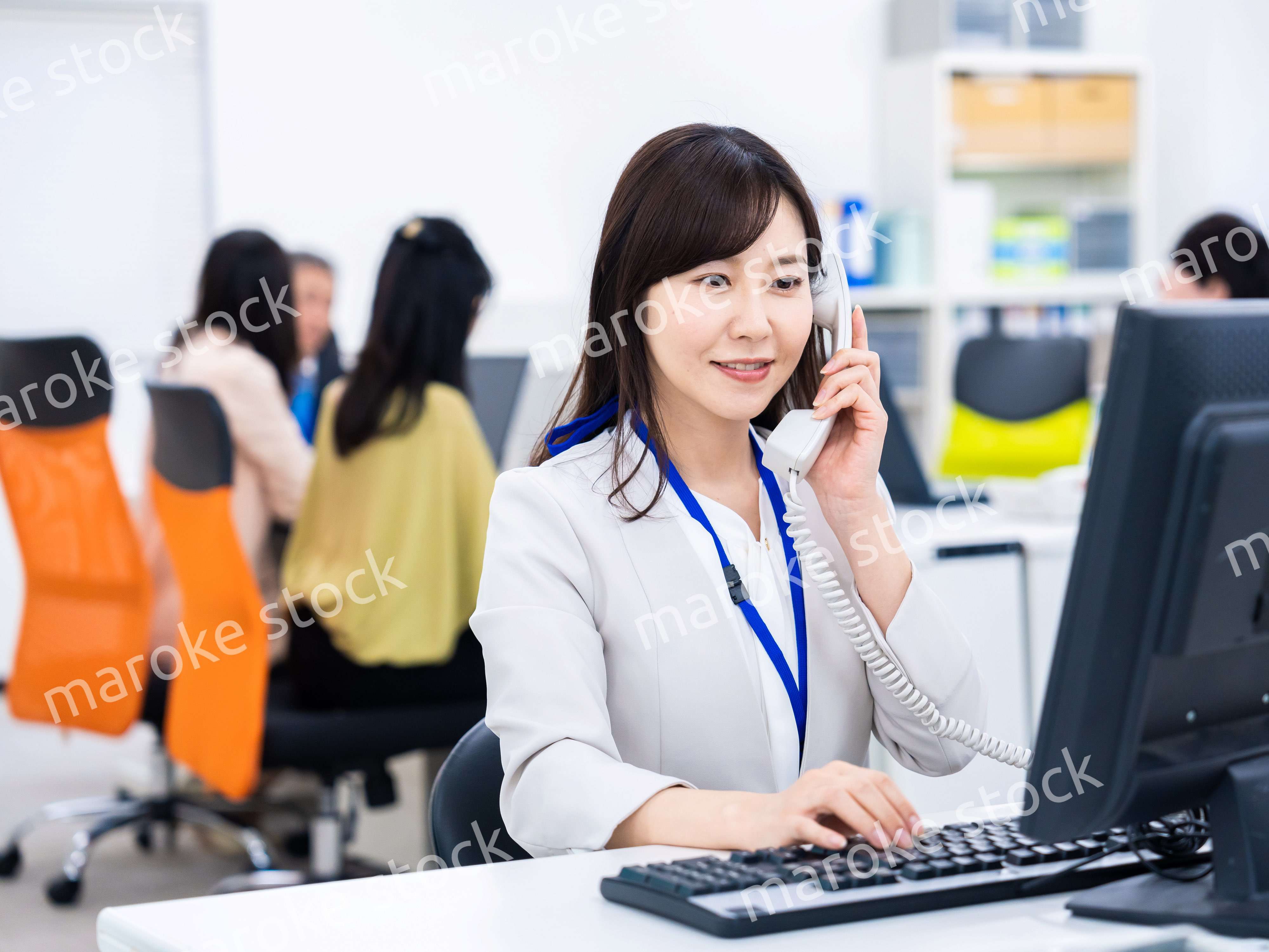 オフィスで固定電話を使う女性