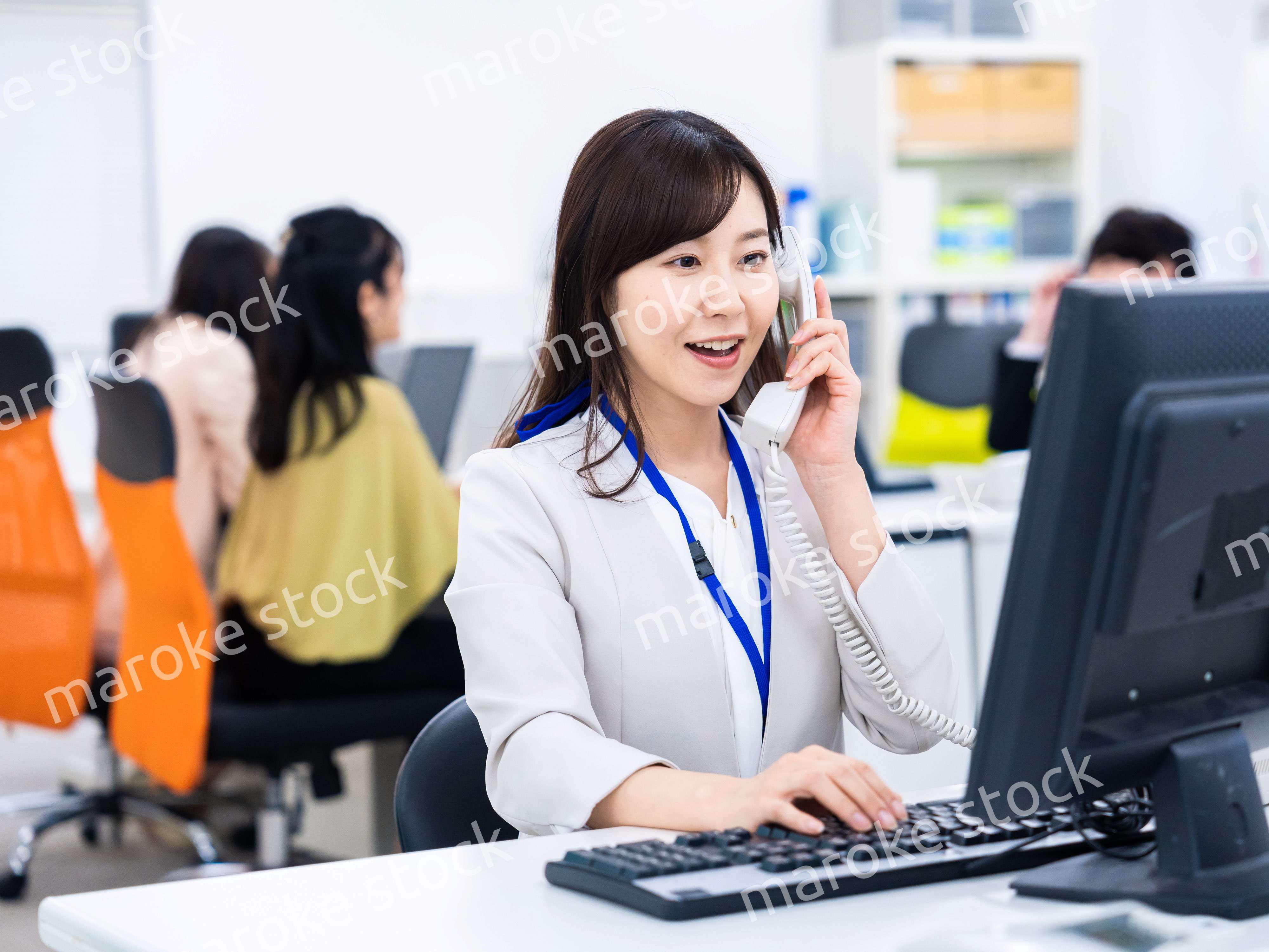 オフィスで固定電話を使う女性