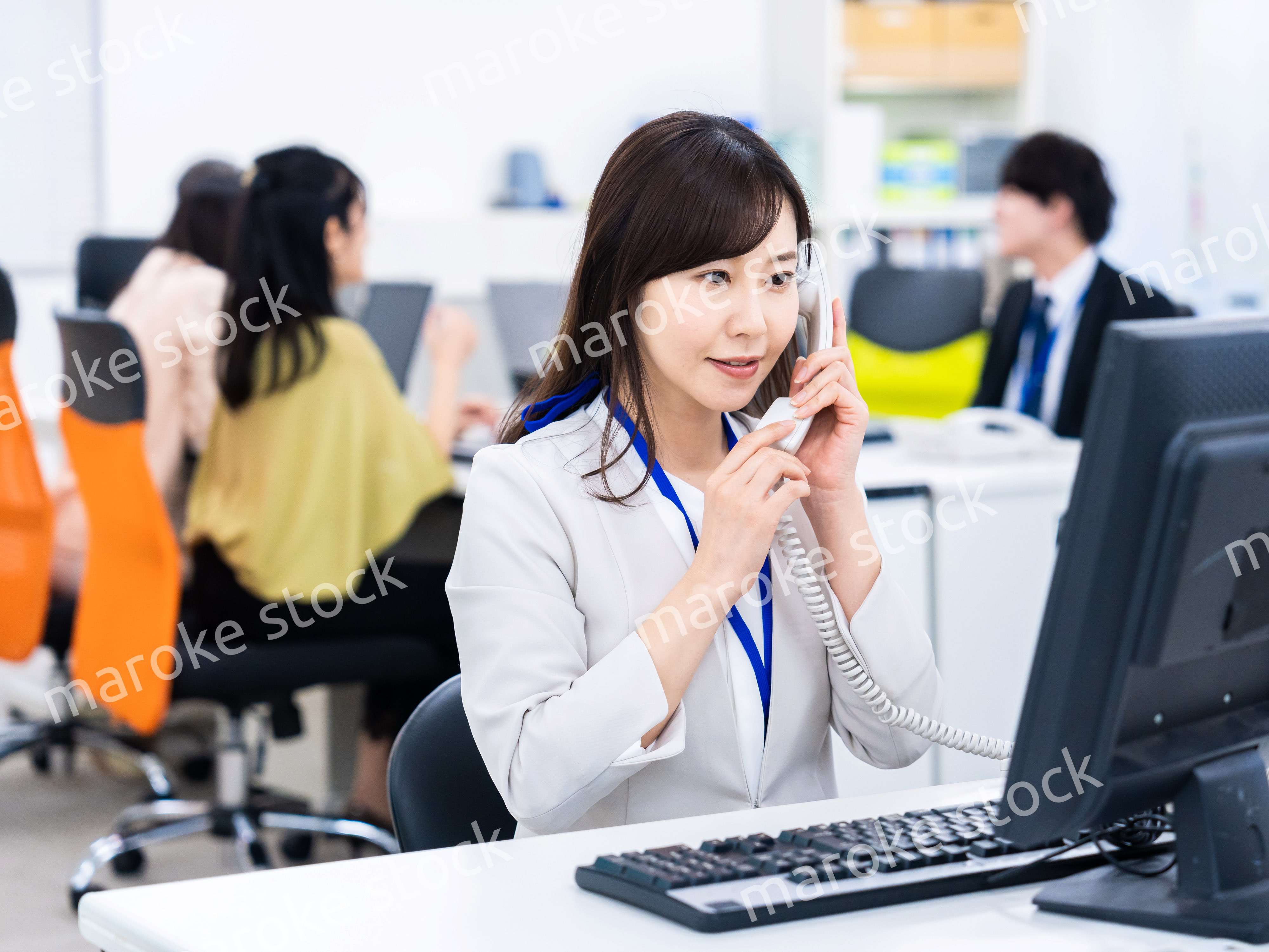 オフィスで固定電話を使う女性