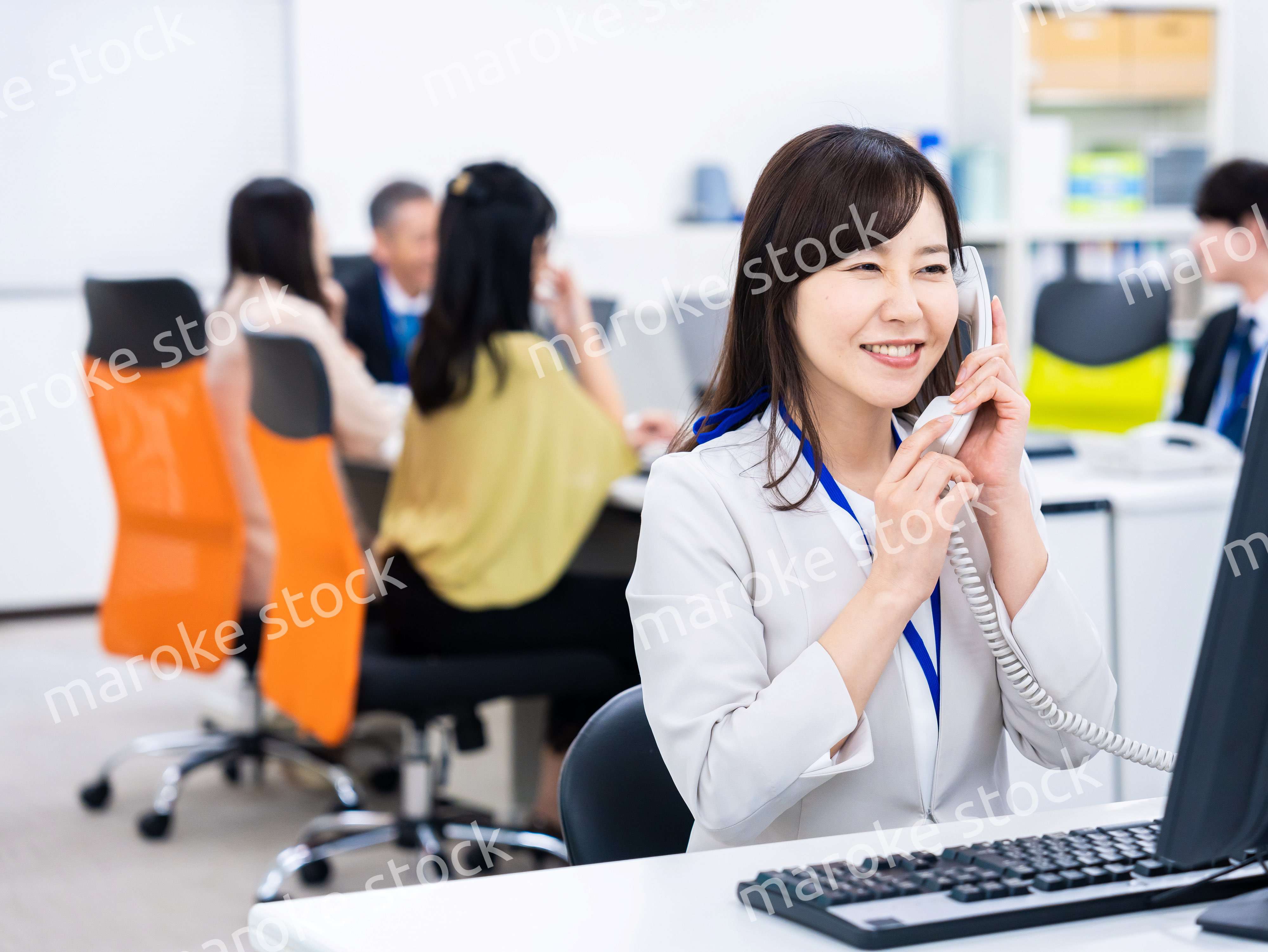 オフィスで固定電話を使う女性