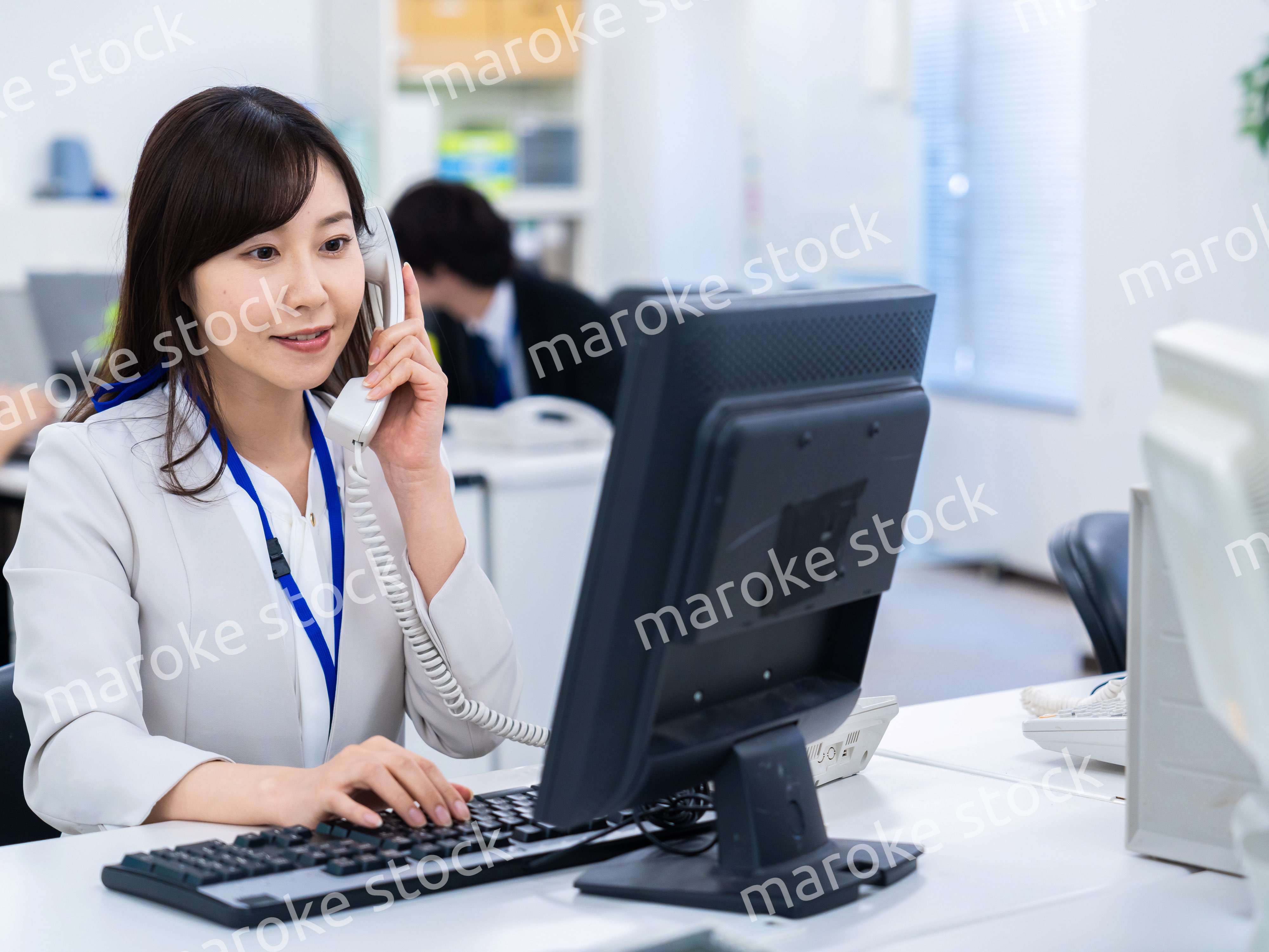 オフィスで固定電話を使う女性