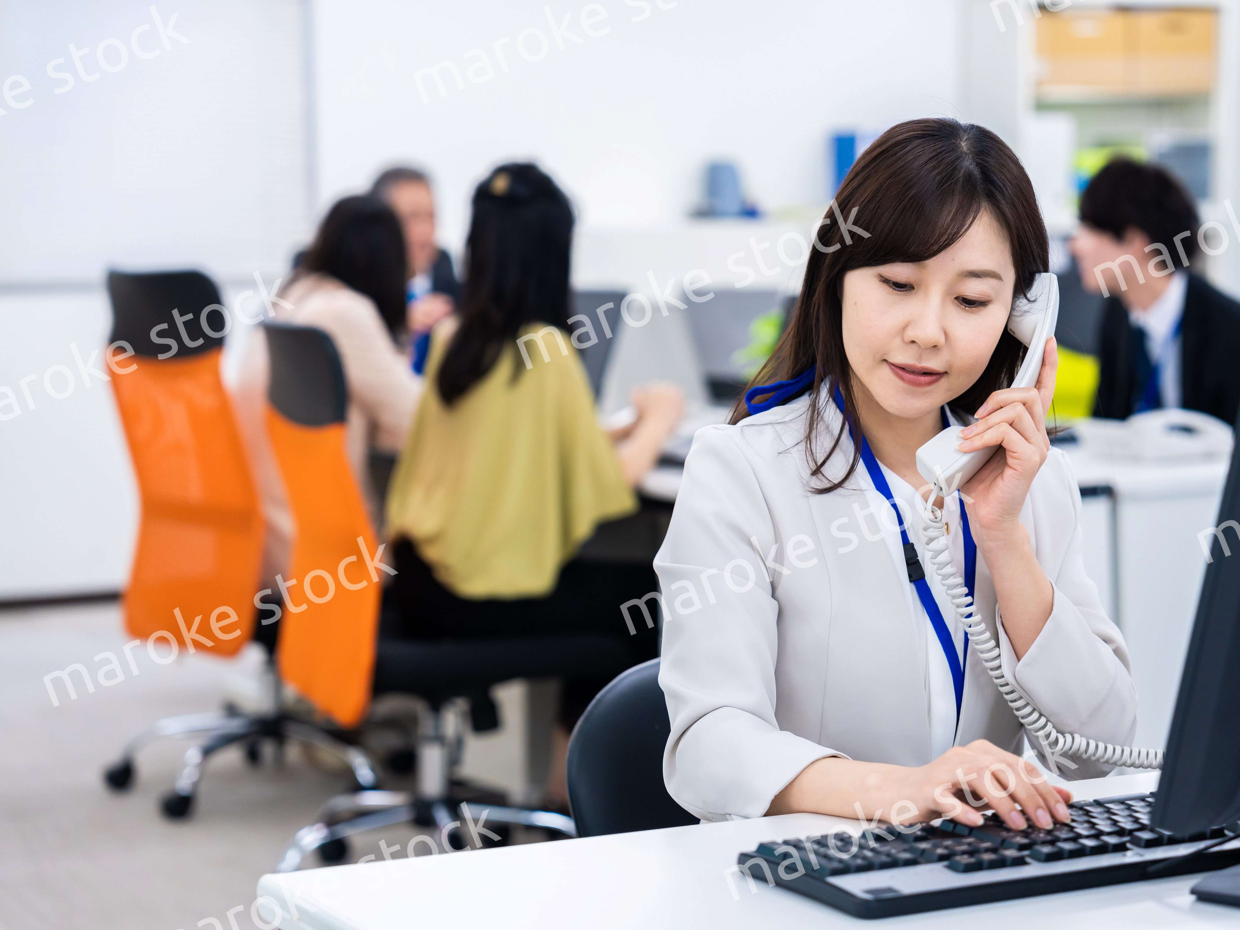 オフィスで固定電話を使う女性