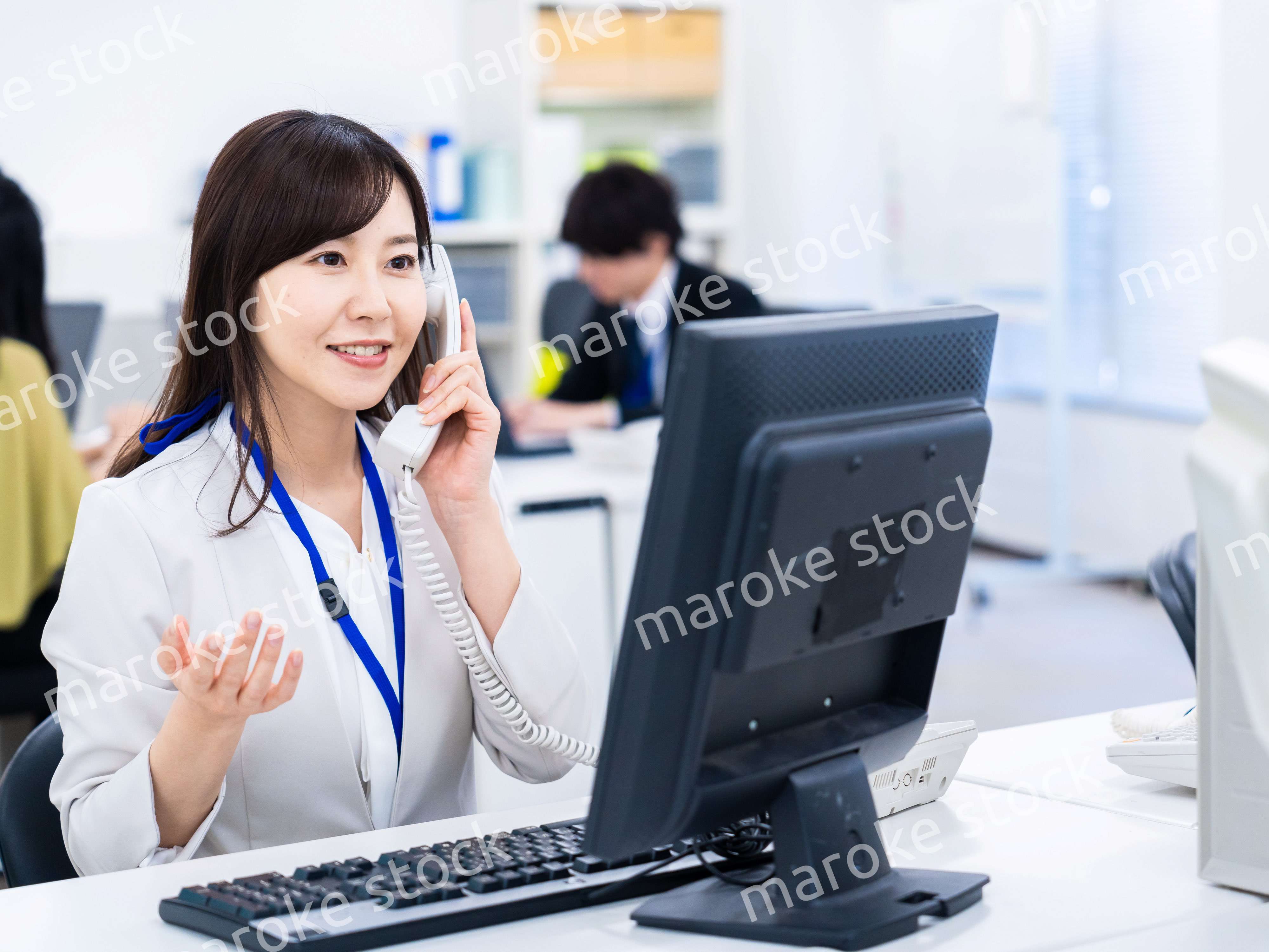 オフィスで固定電話を使う女性