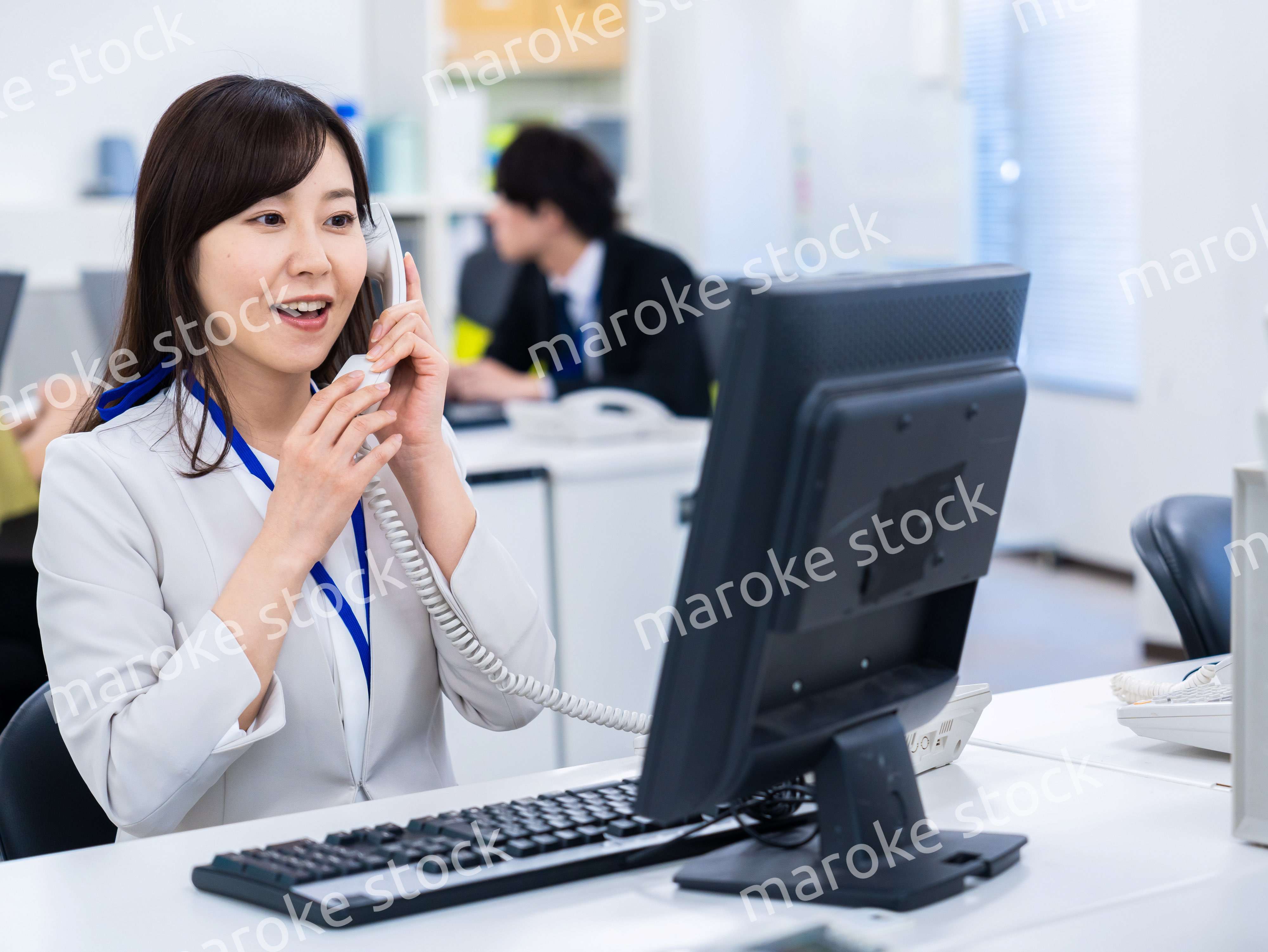 オフィスで固定電話を使う女性