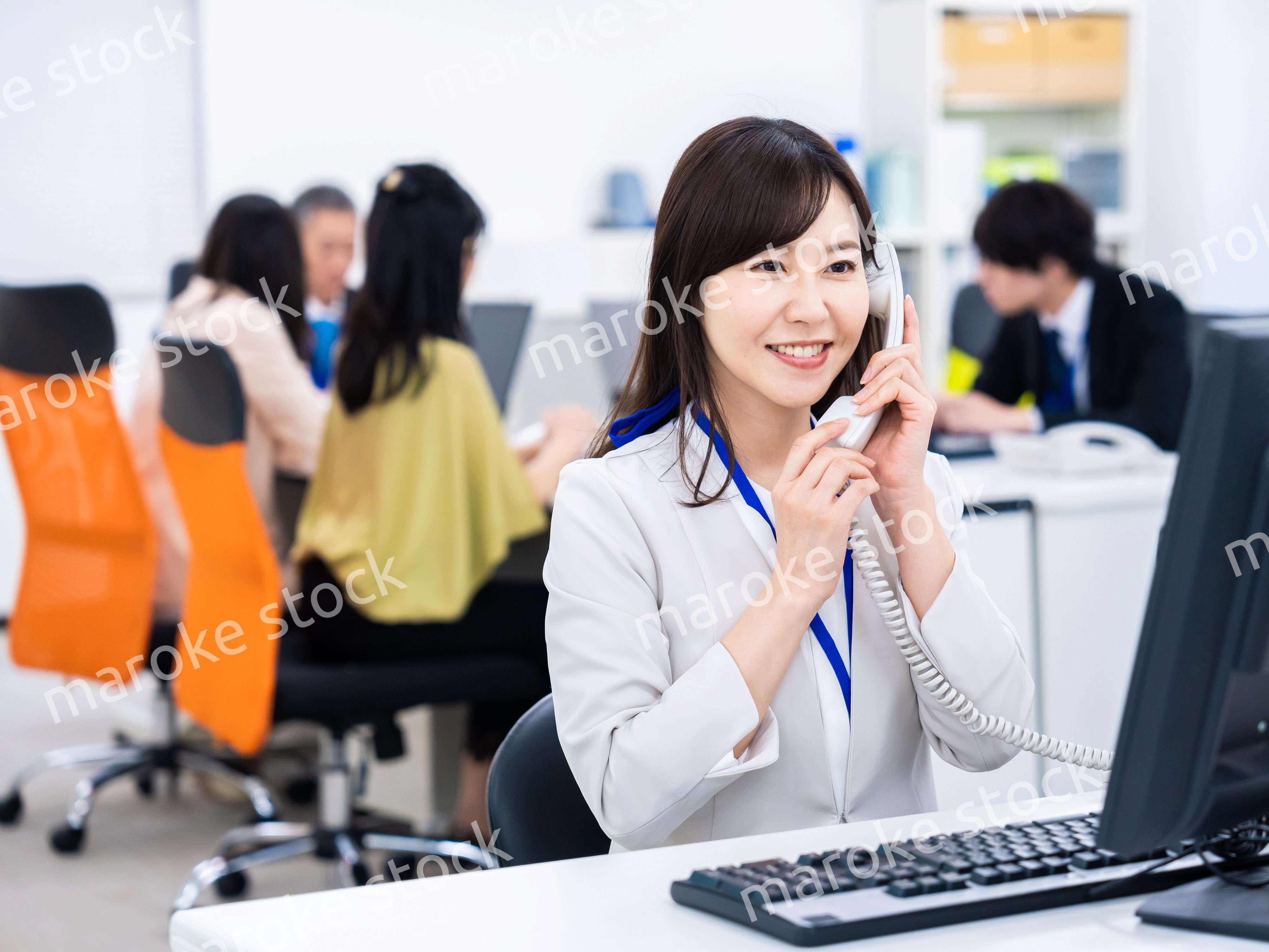 オフィスで固定電話を使う女性