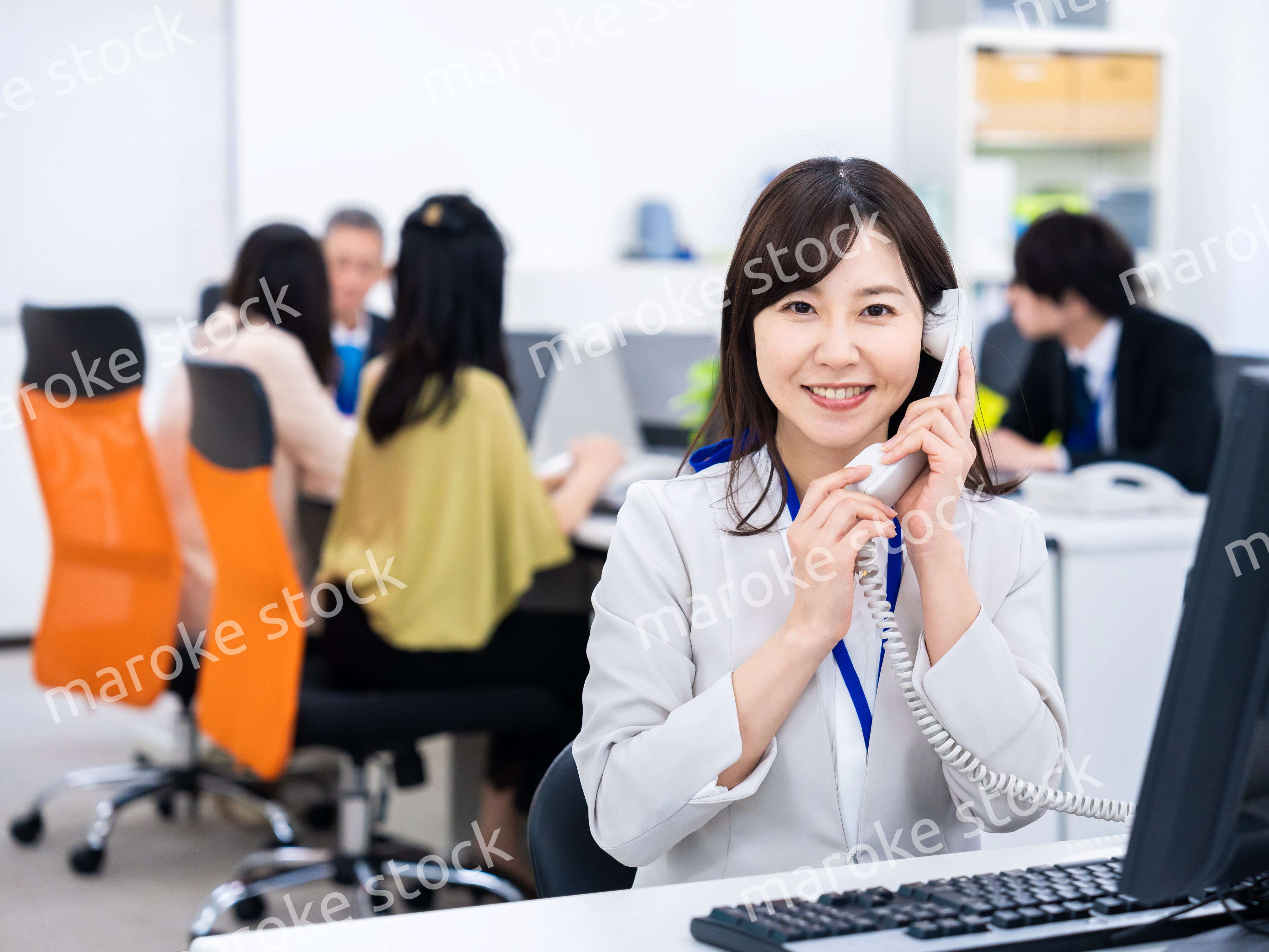 オフィスで固定電話を使う女性