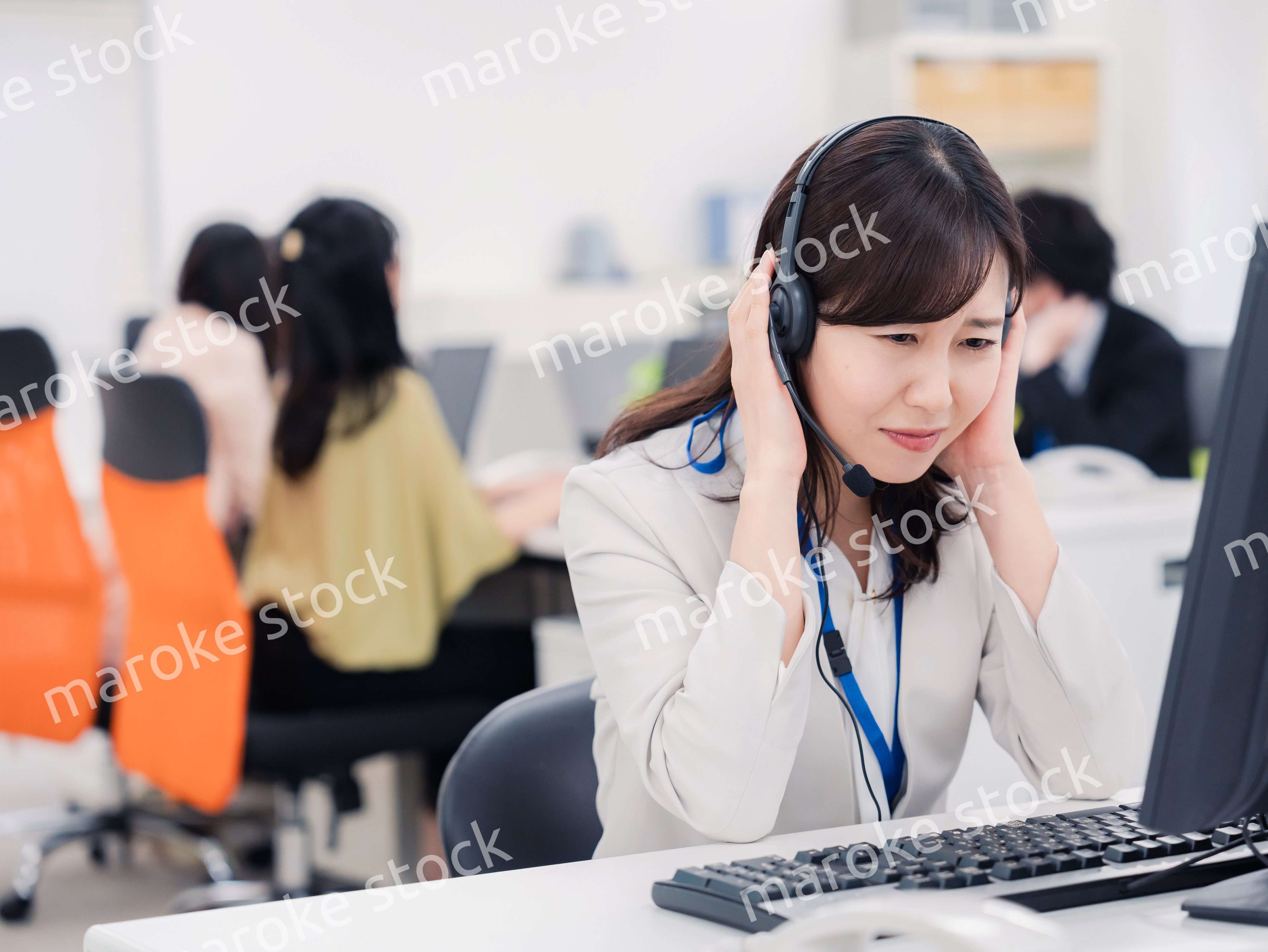 電話対応で疲労するお客様センターの女性