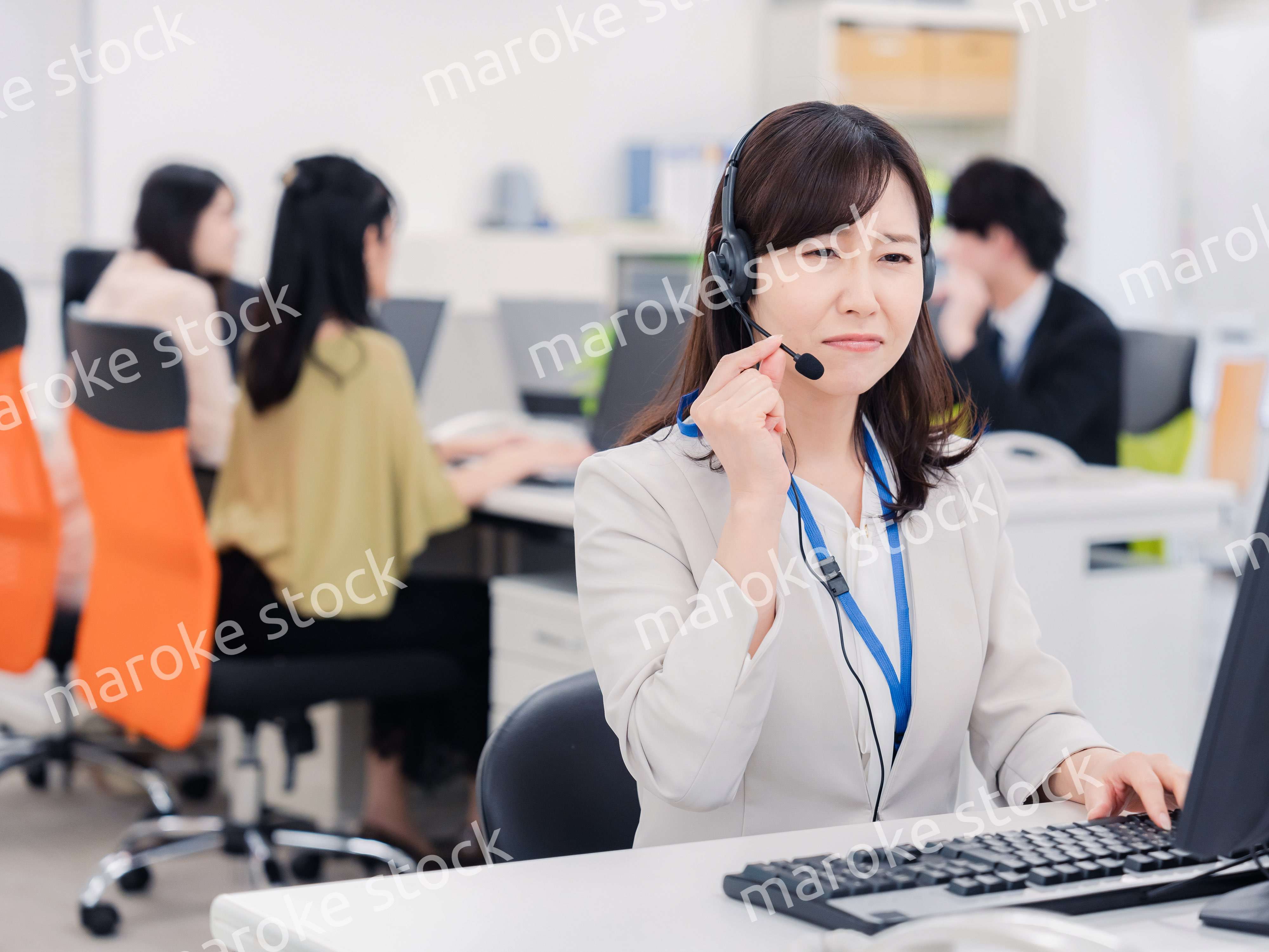 電話対応で疲労するお客様センターの女性