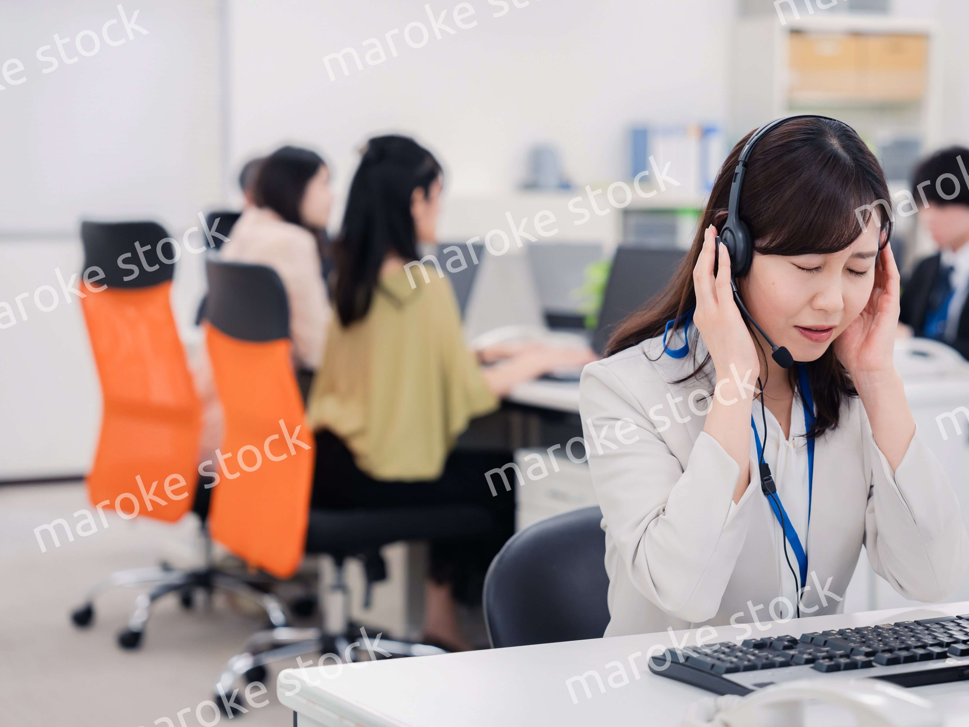 電話対応で疲労するお客様センターの女性