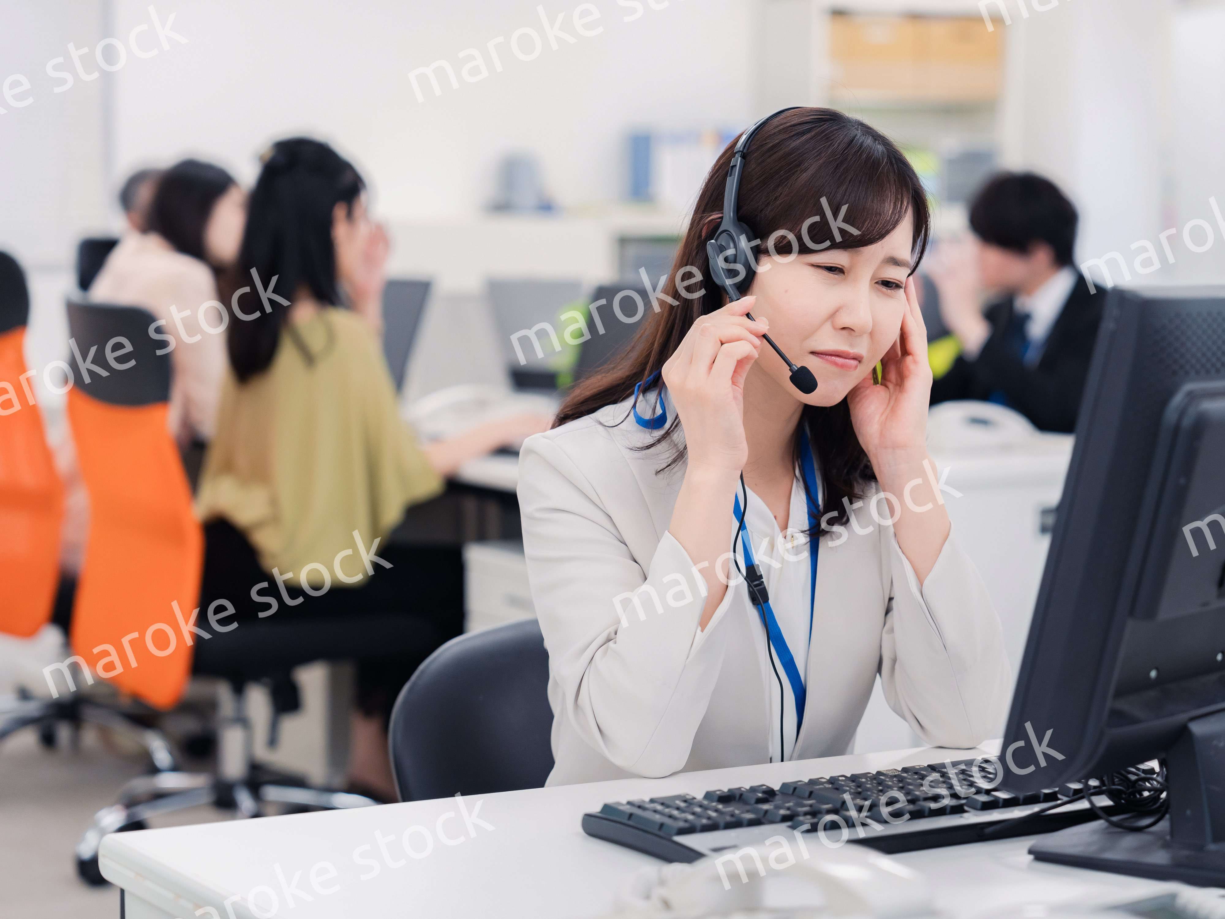 電話対応で疲労するお客様センターの女性