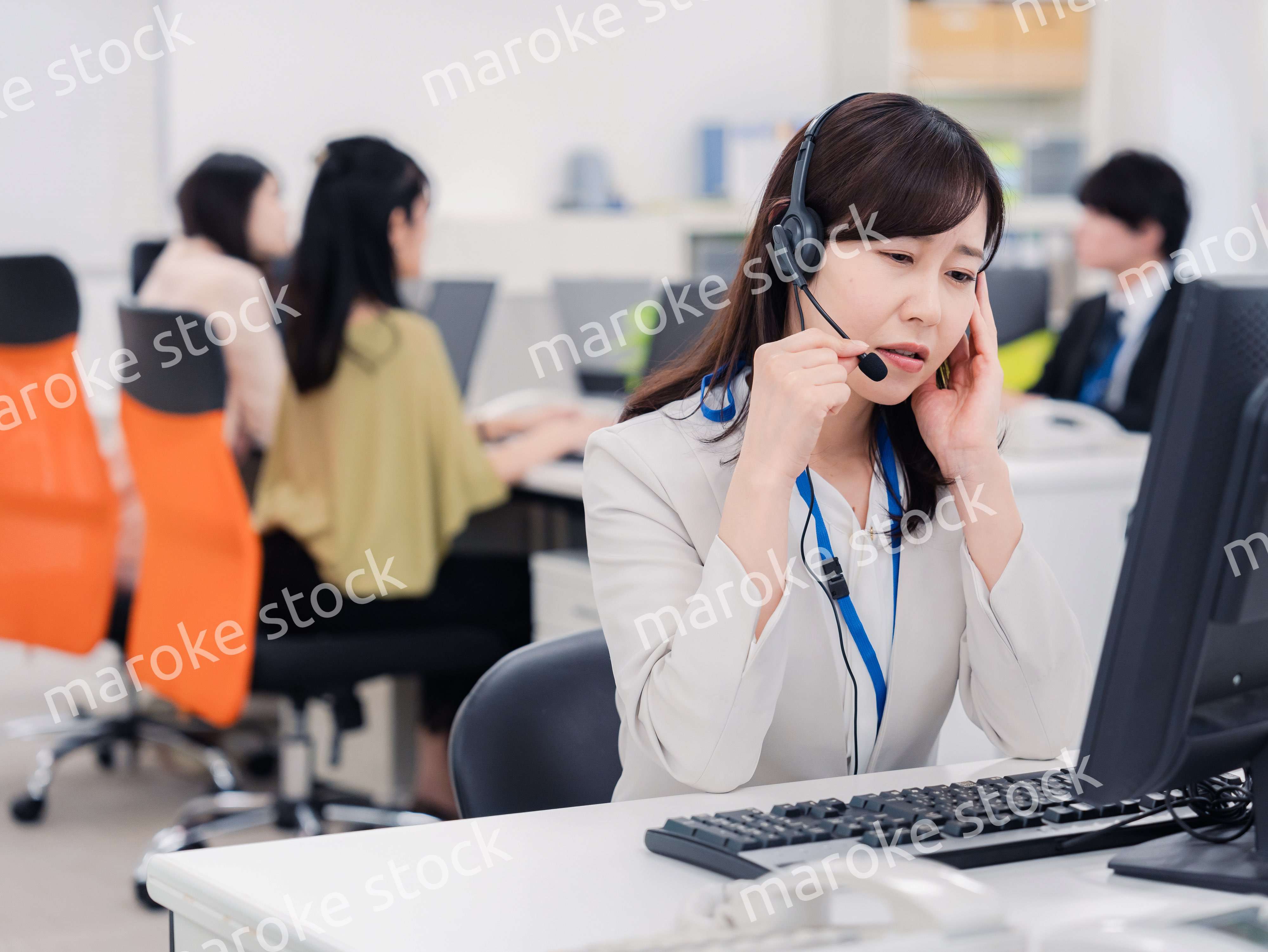 電話対応で疲労するお客様センターの女性