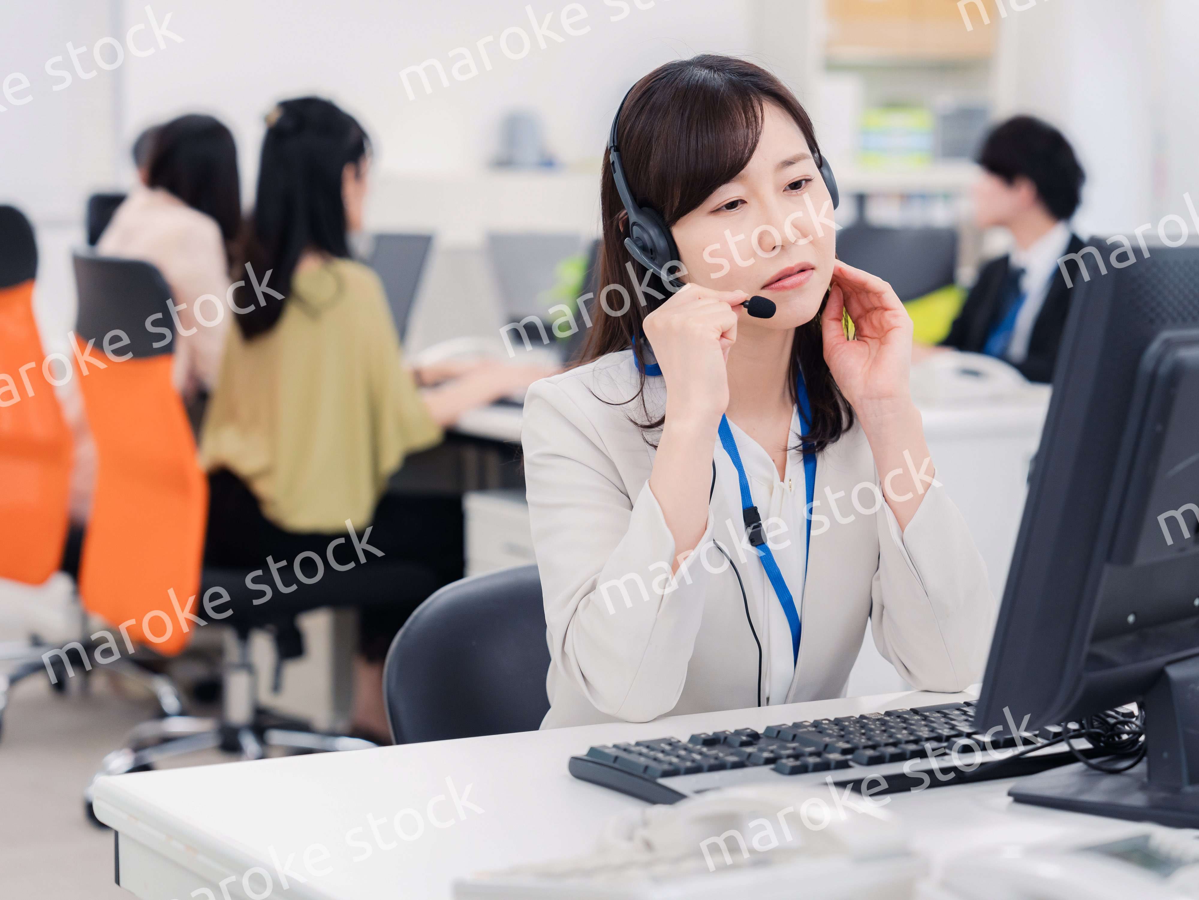 電話対応で疲労するお客様センターの女性