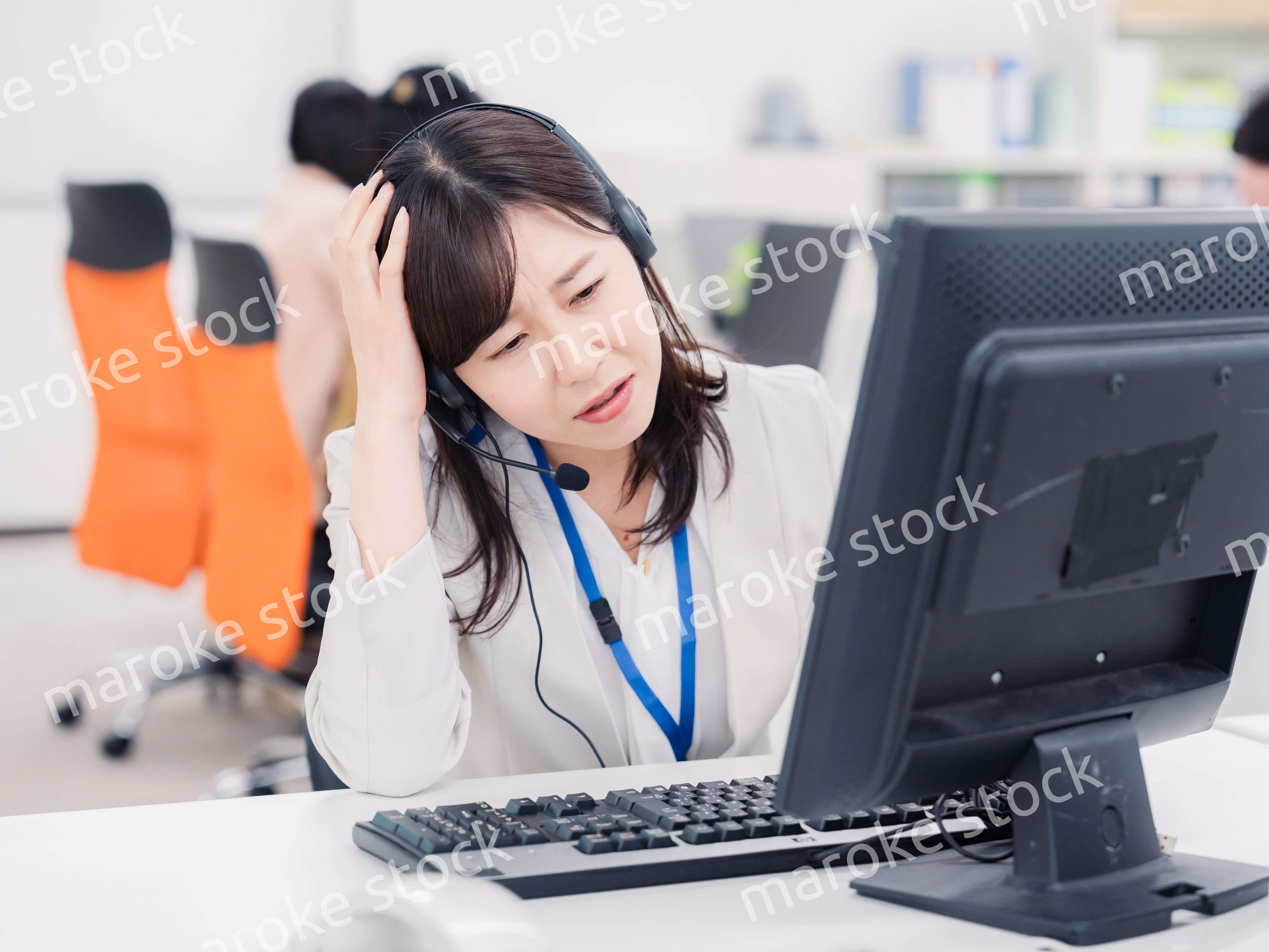 電話対応で疲労するお客様センターの女性