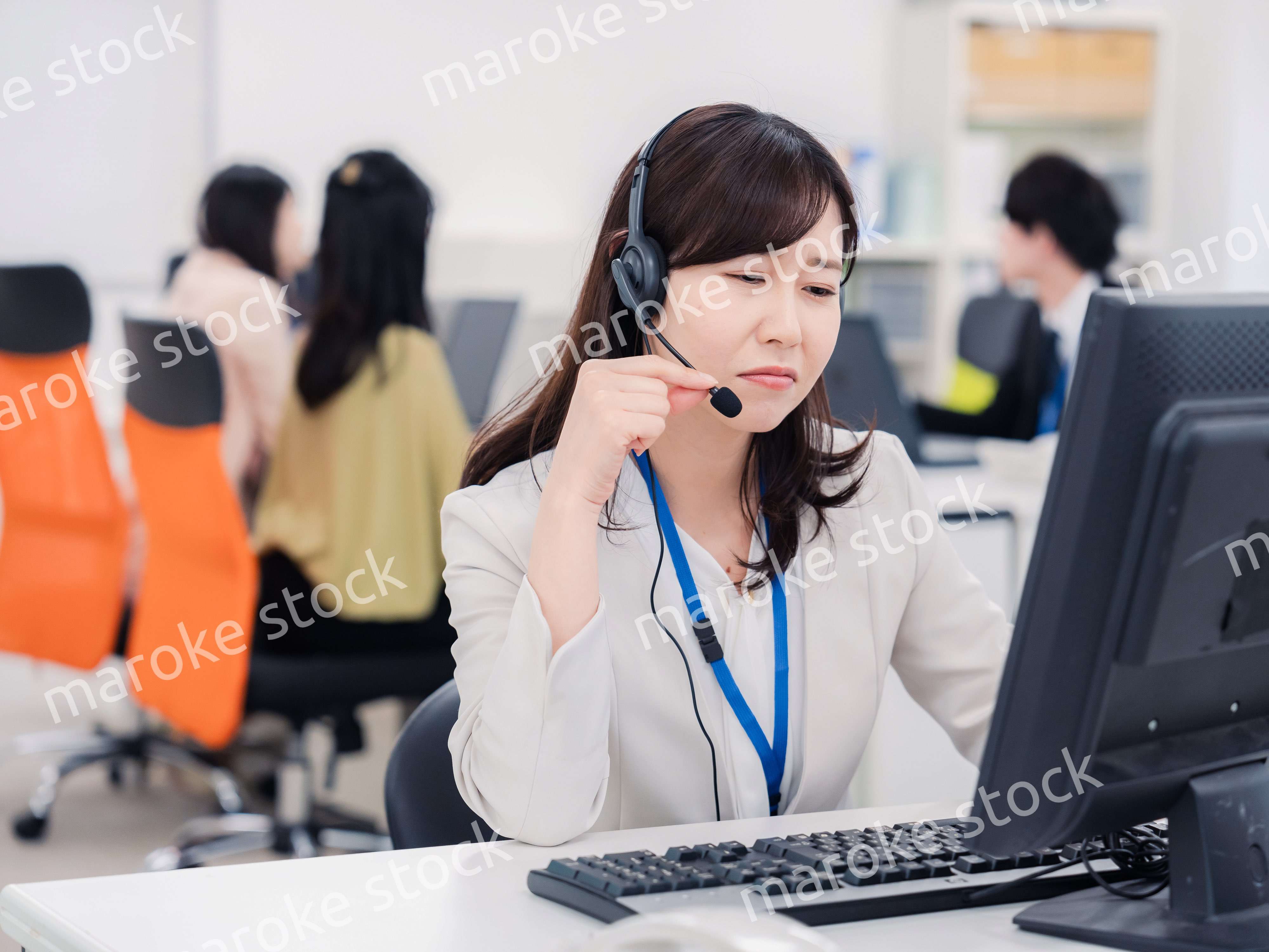 電話対応で疲労するお客様センターの女性