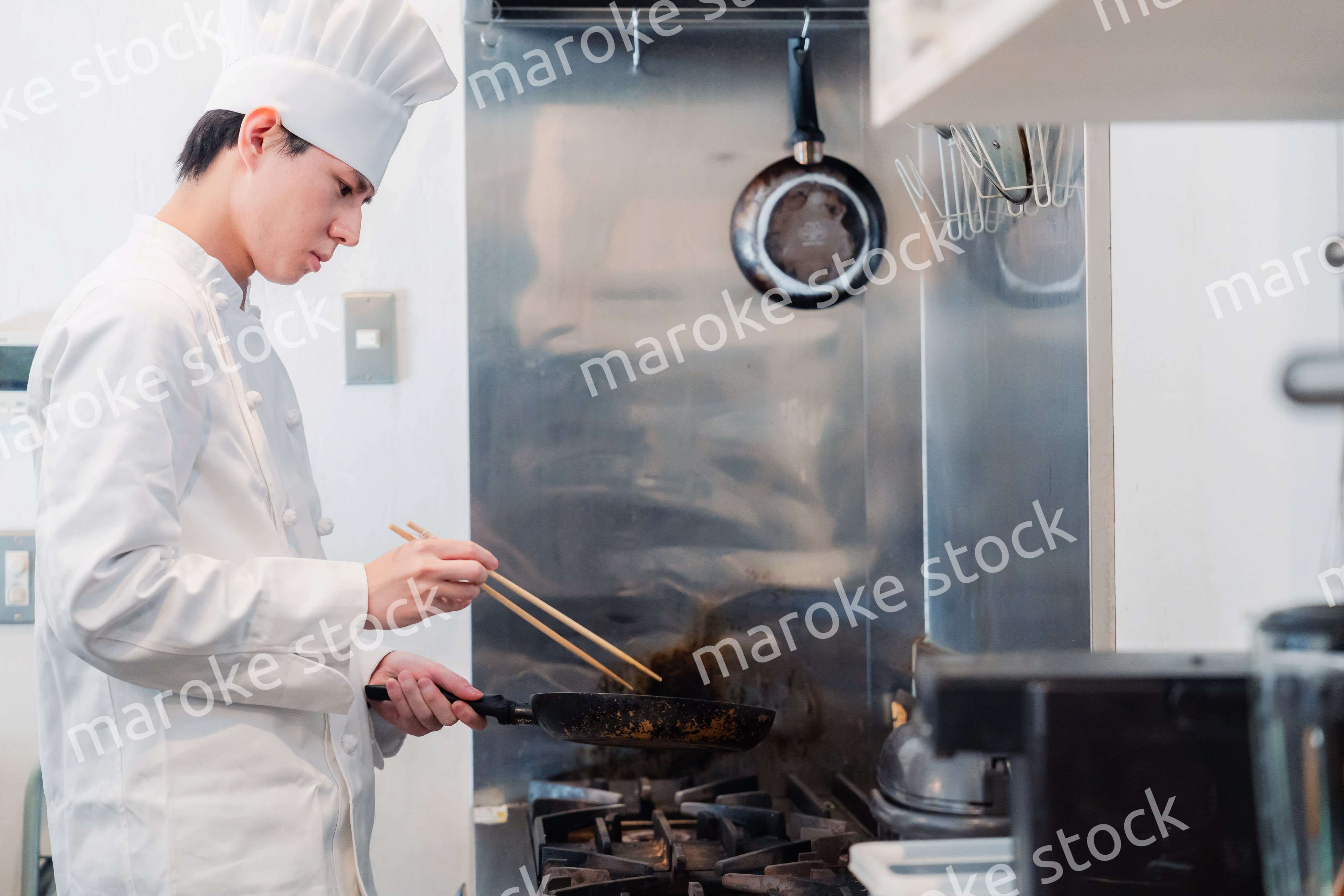 フライパンで調理をする男性シェフ