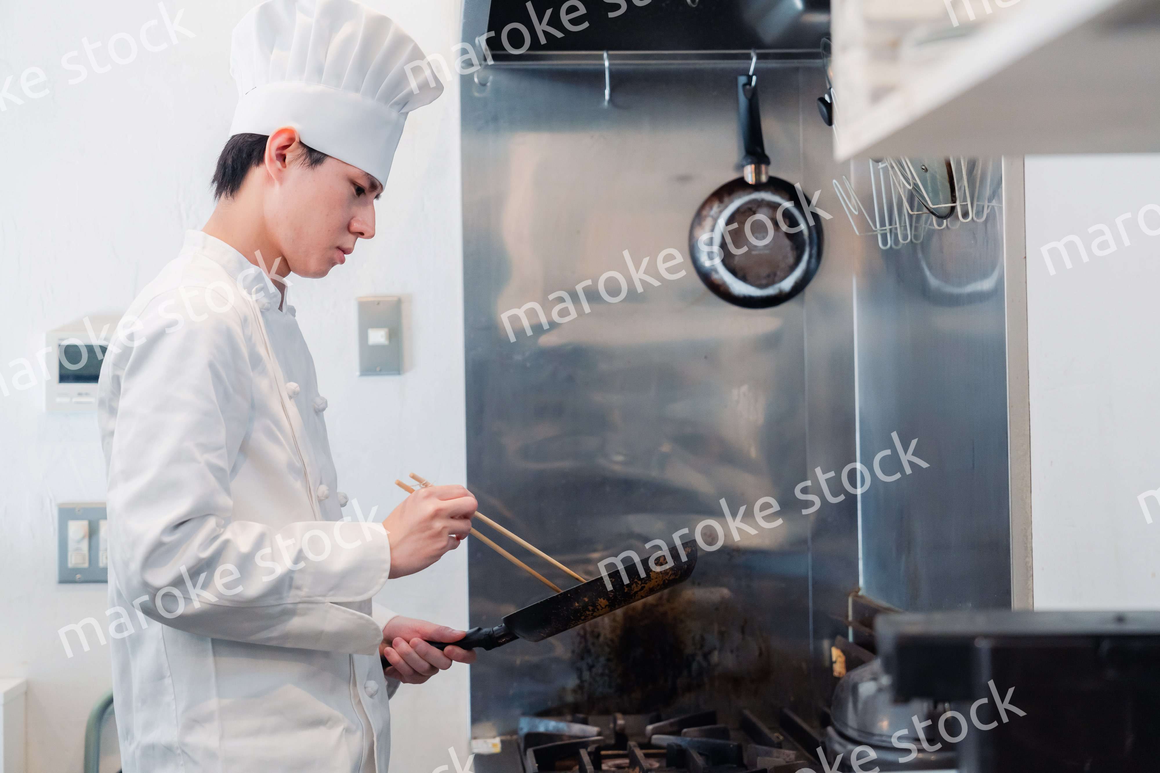 フライパンで調理をする男性シェフ