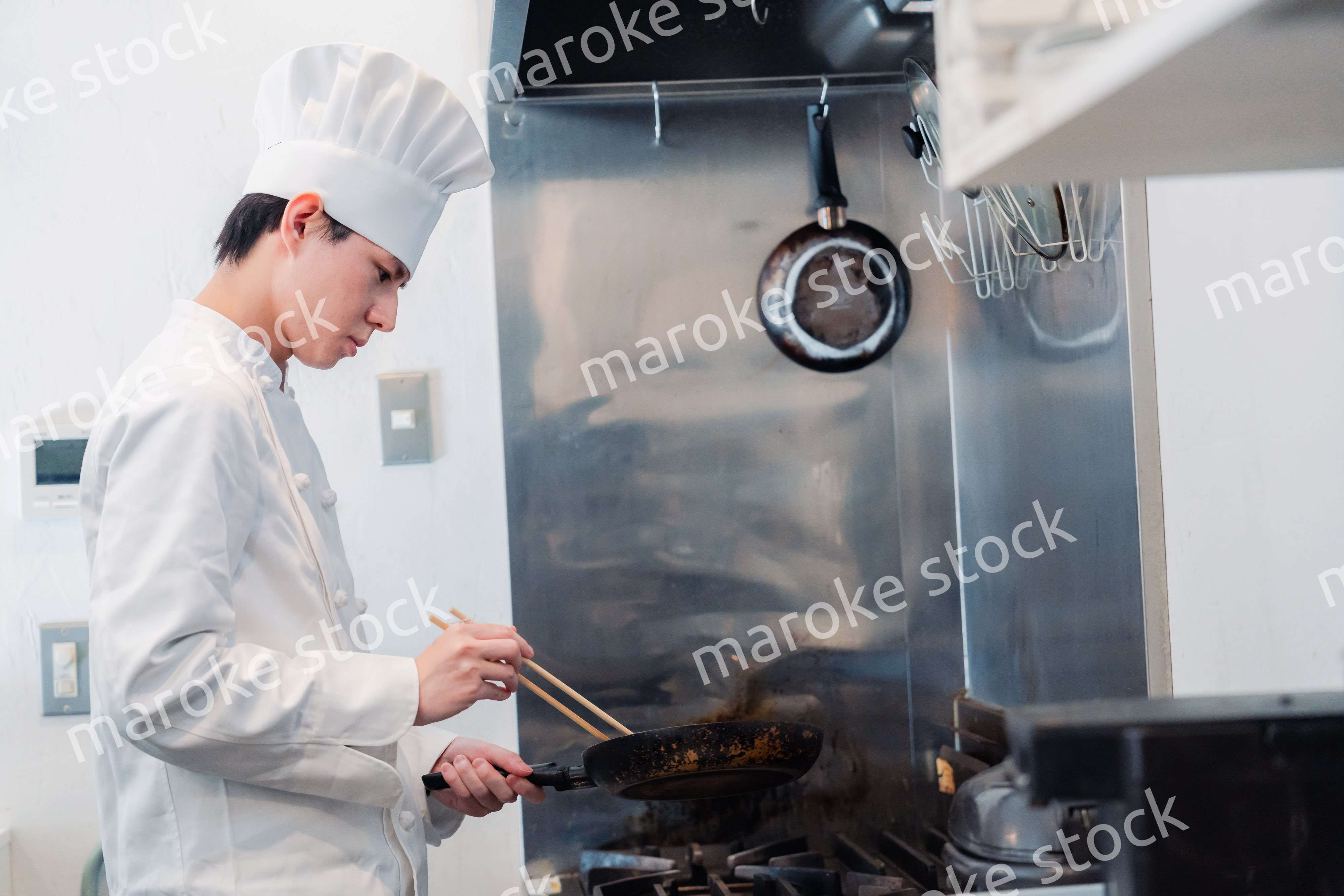 フライパンで調理をする男性シェフ