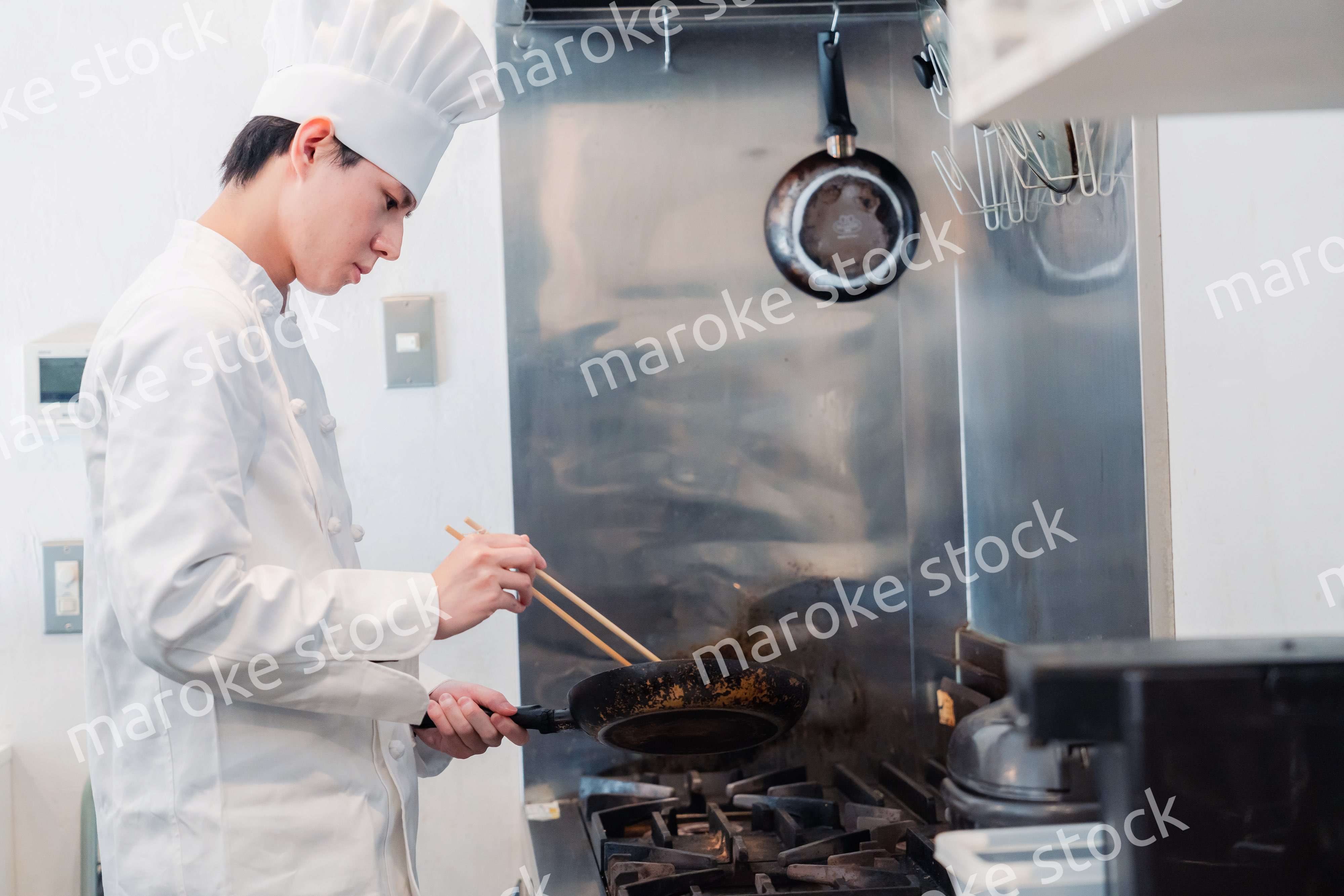 フライパンで調理をする男性シェフ
