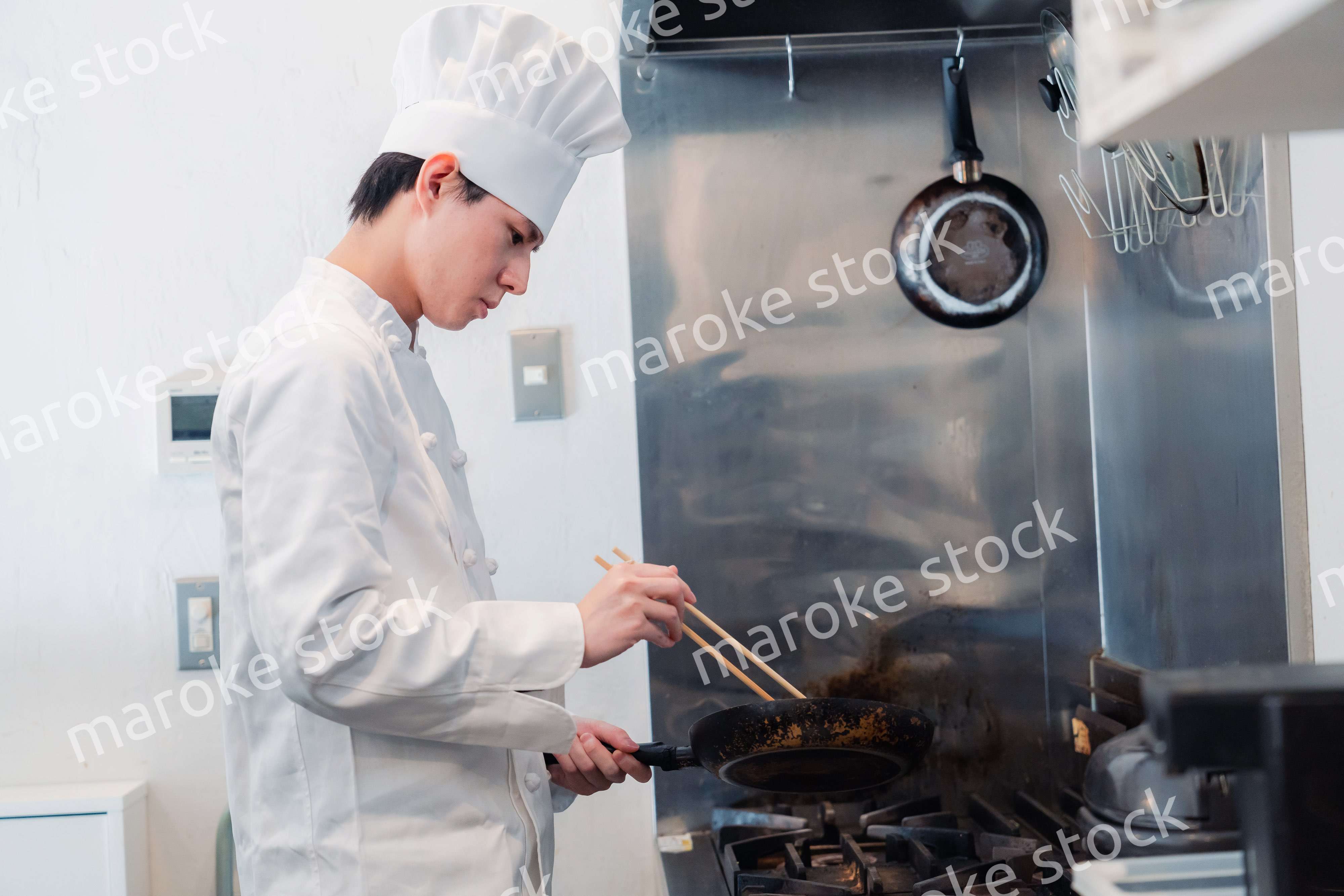 フライパンで調理をする男性シェフ