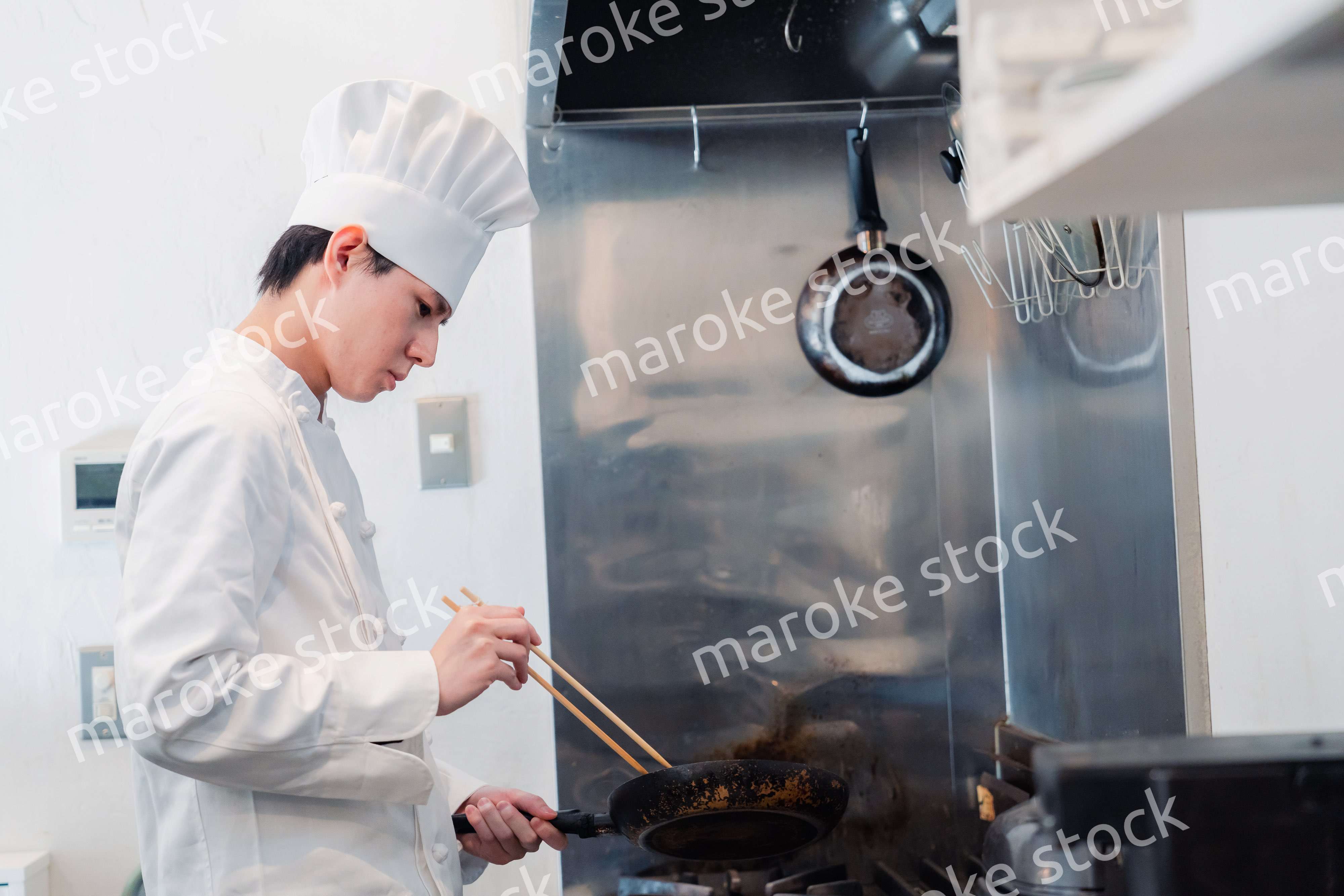 フライパンで調理をする男性シェフ