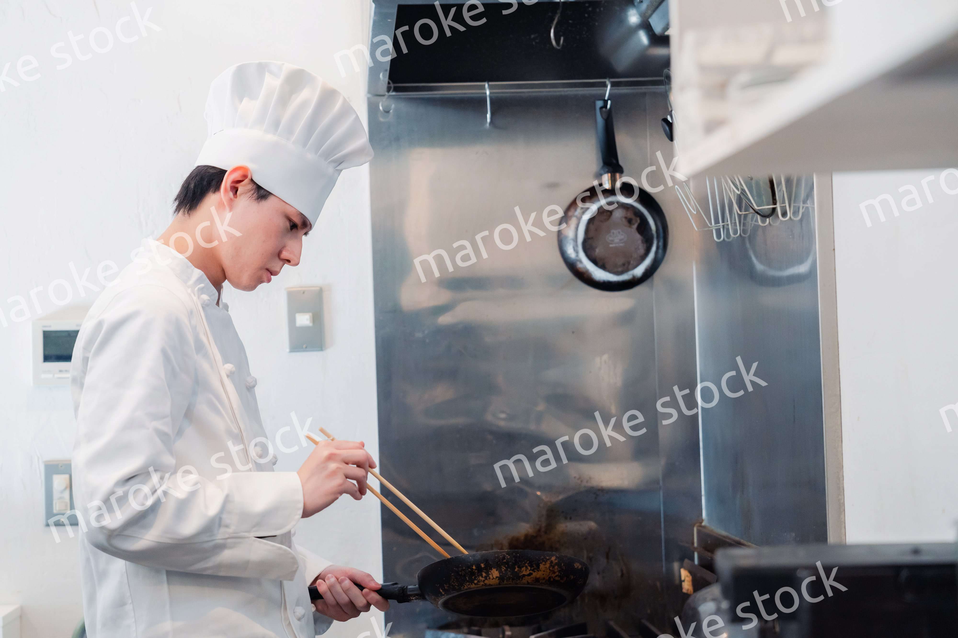 フライパンで調理をする男性シェフ