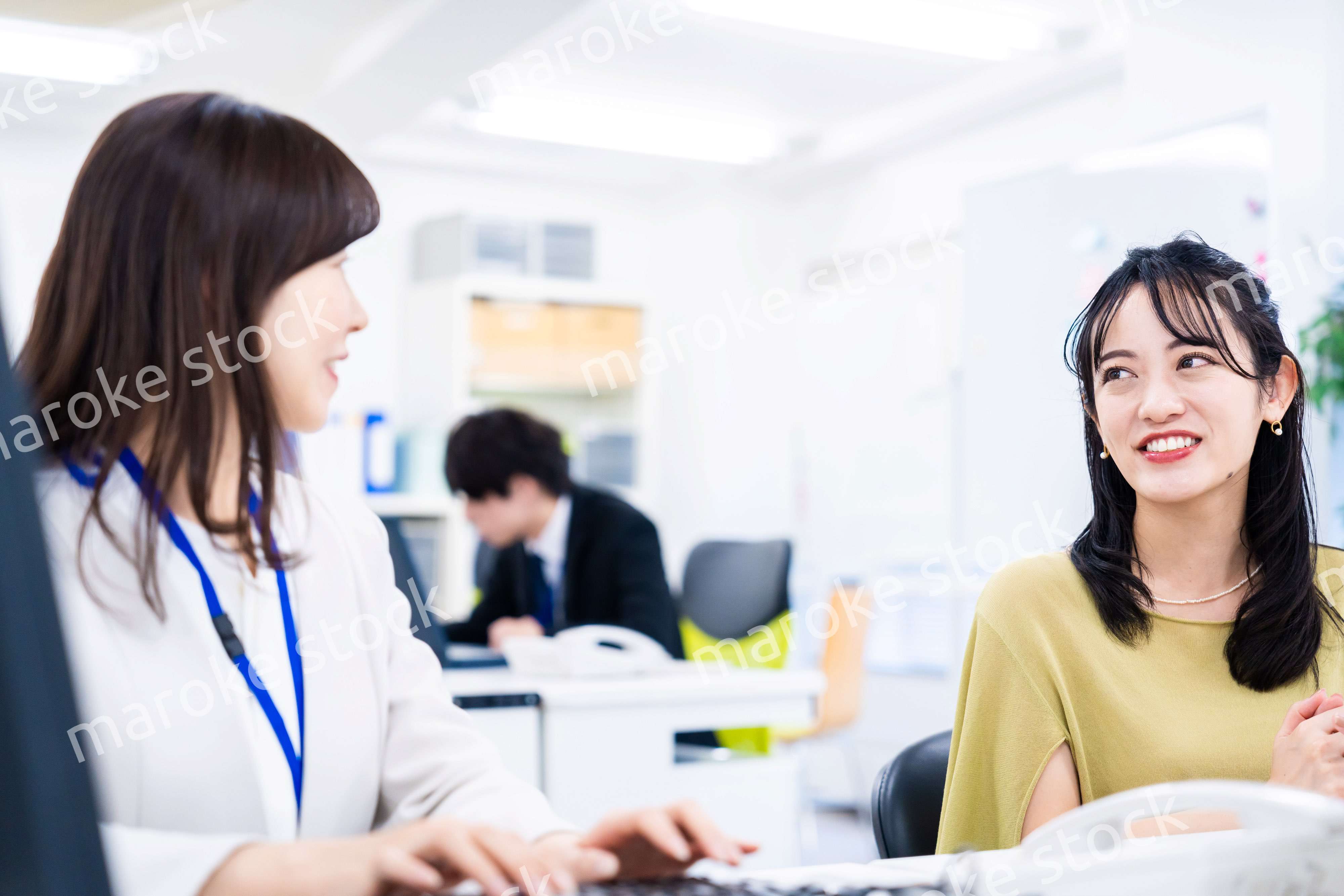 楽しく話をしながらデスクワークをする女性