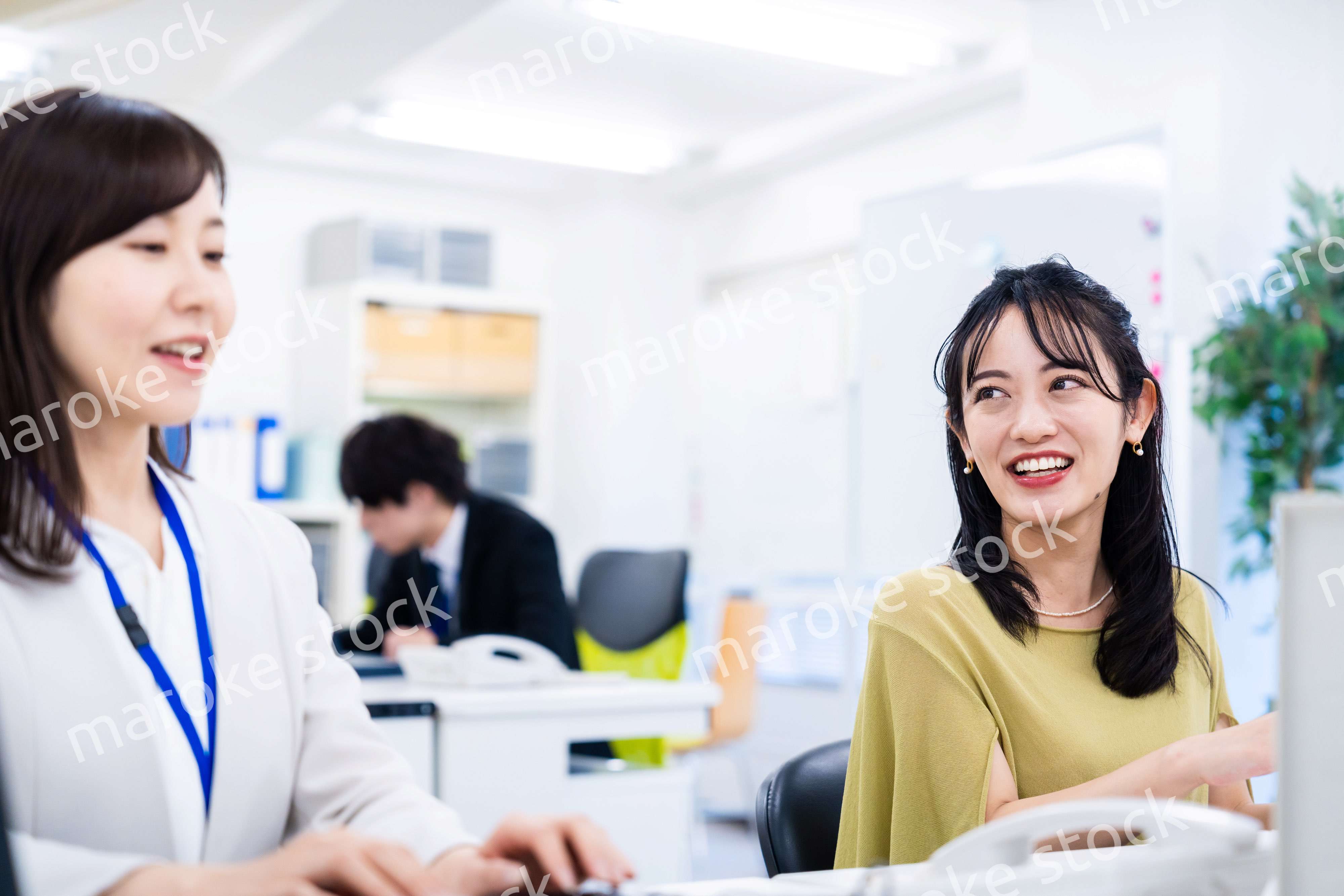 楽しく話をしながらデスクワークをする女性