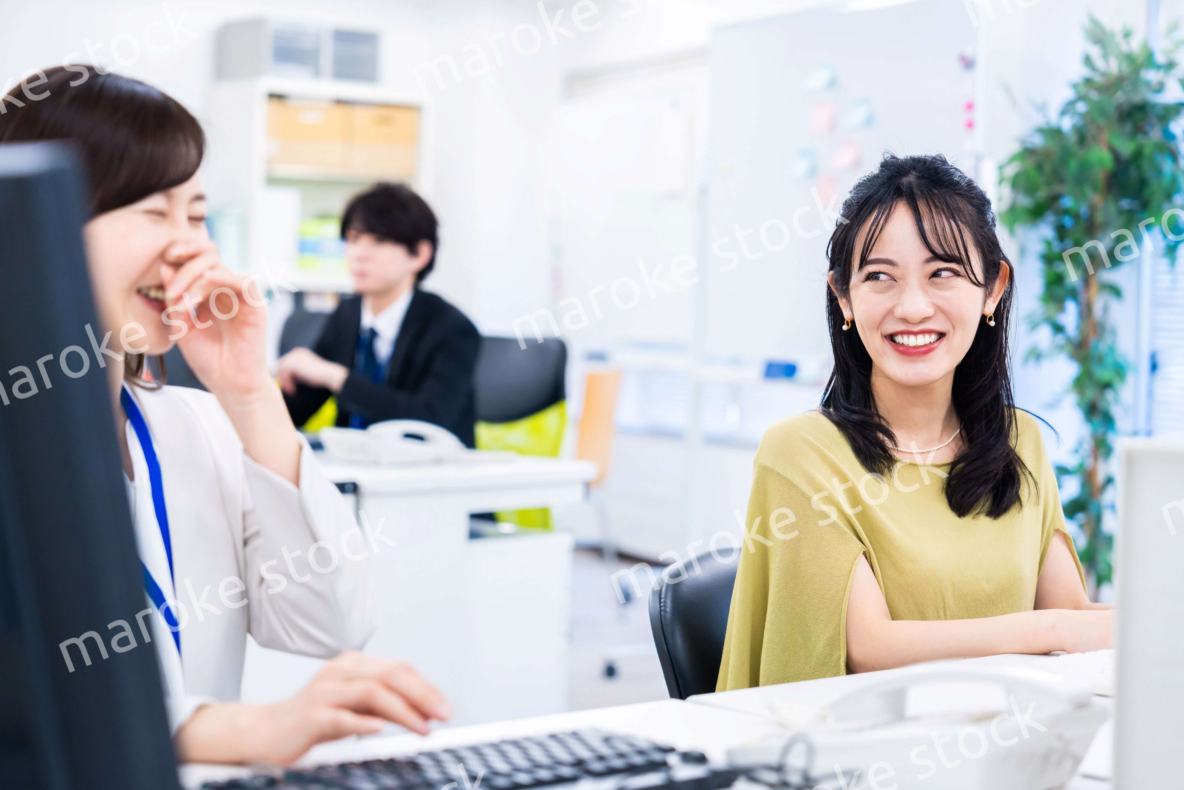 楽しく話をしながらデスクワークをする女性