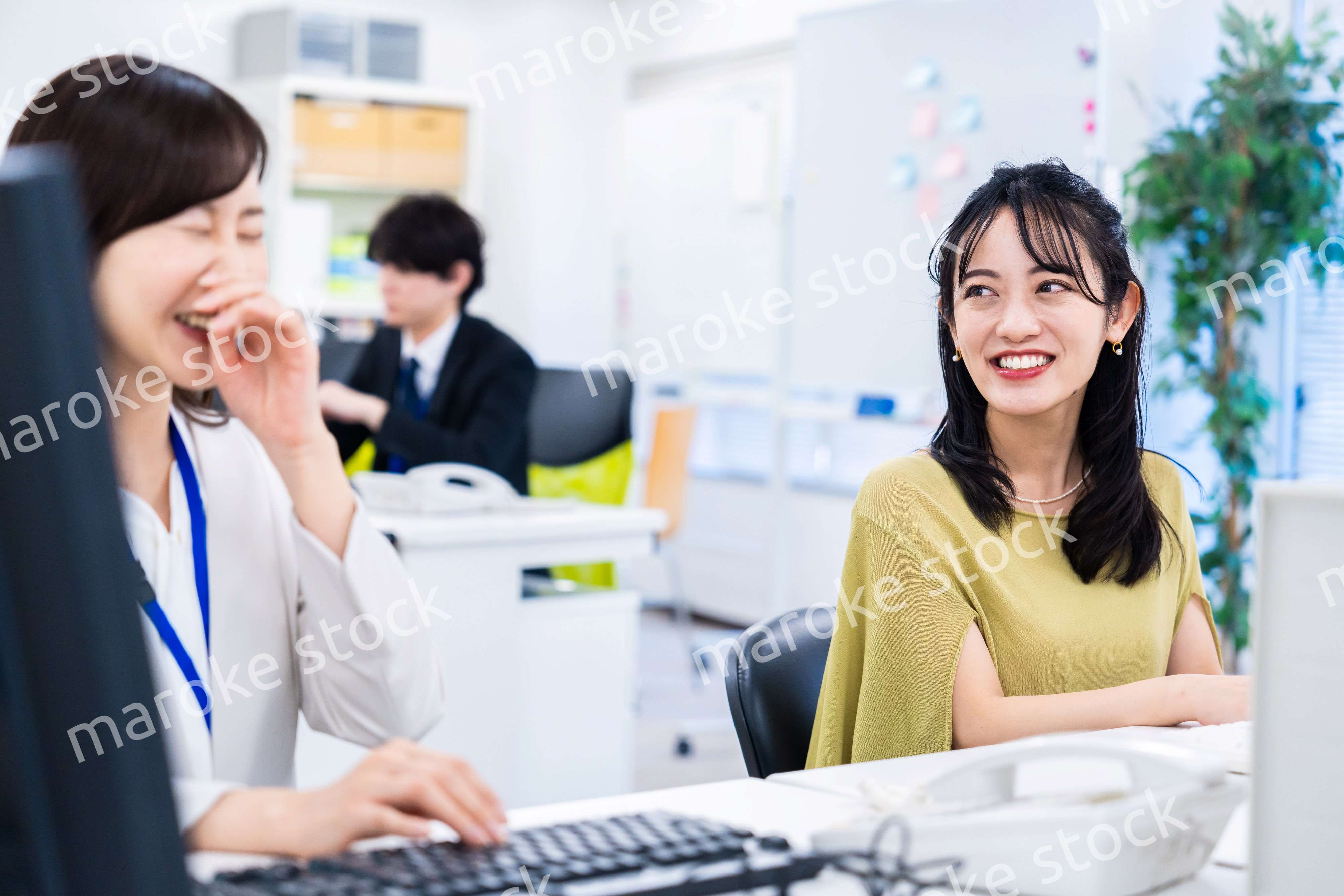 楽しく話をしながらデスクワークをする女性