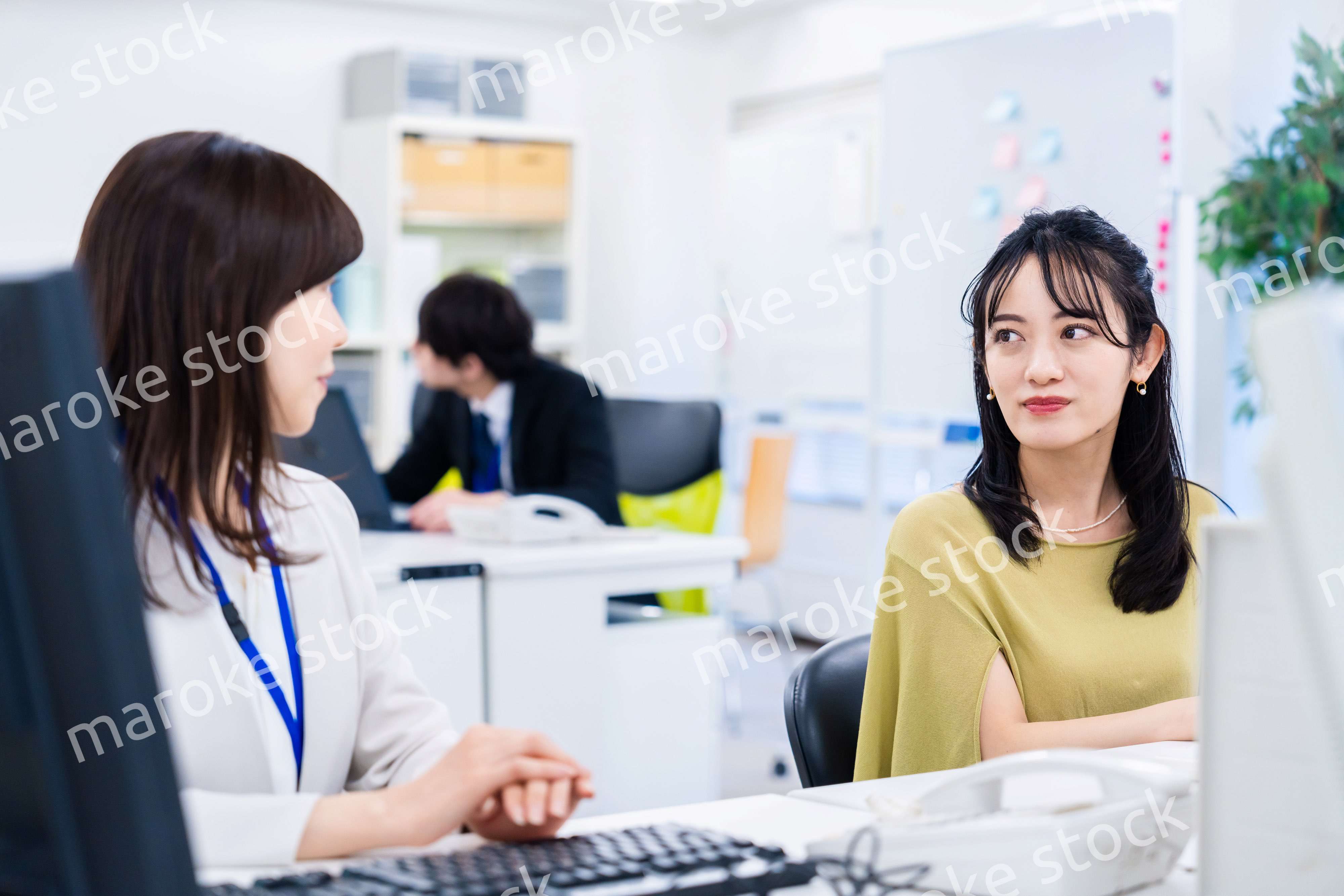 楽しく話をしながらデスクワークをする女性