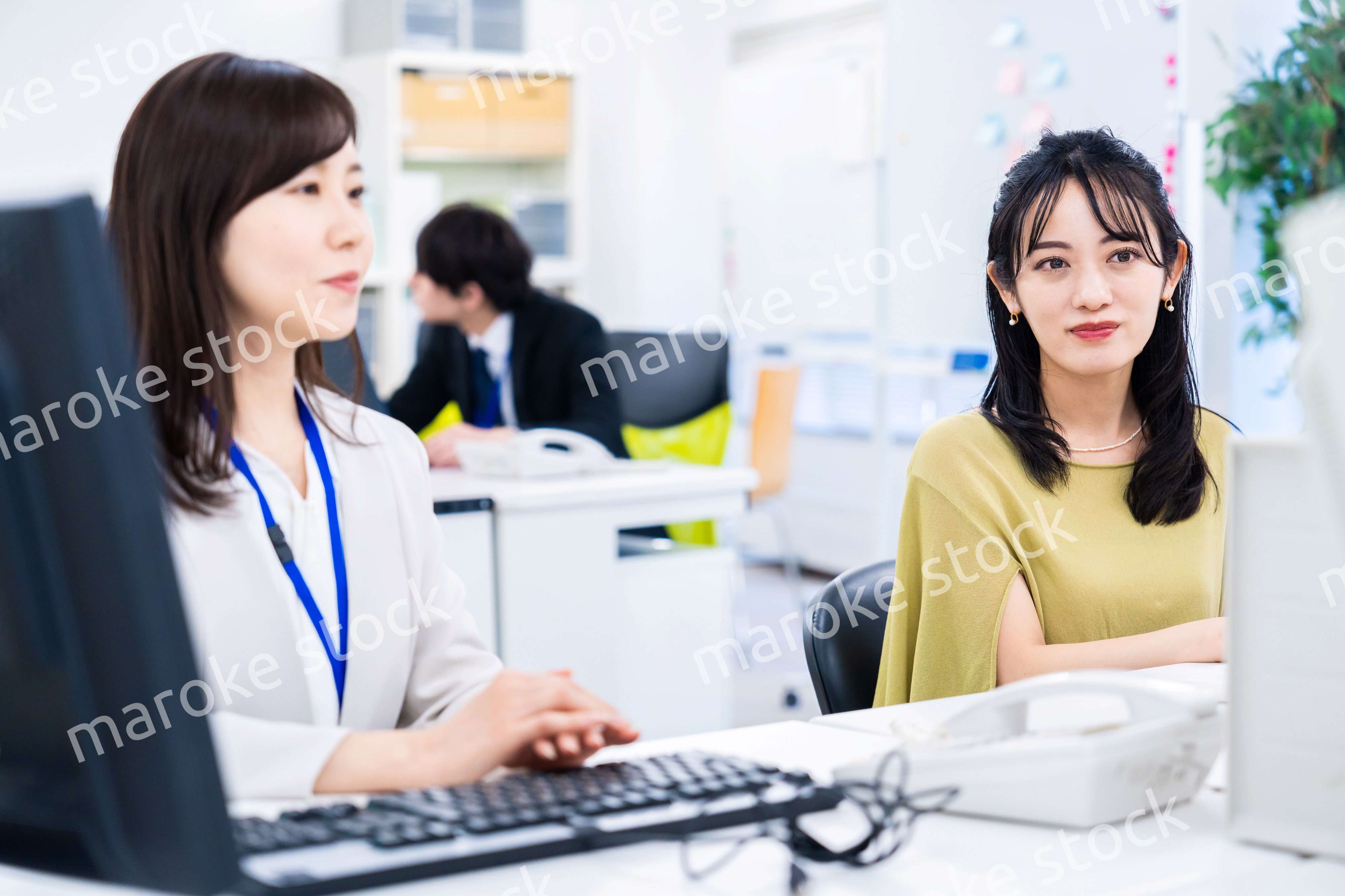 楽しく話をしながらデスクワークをする女性