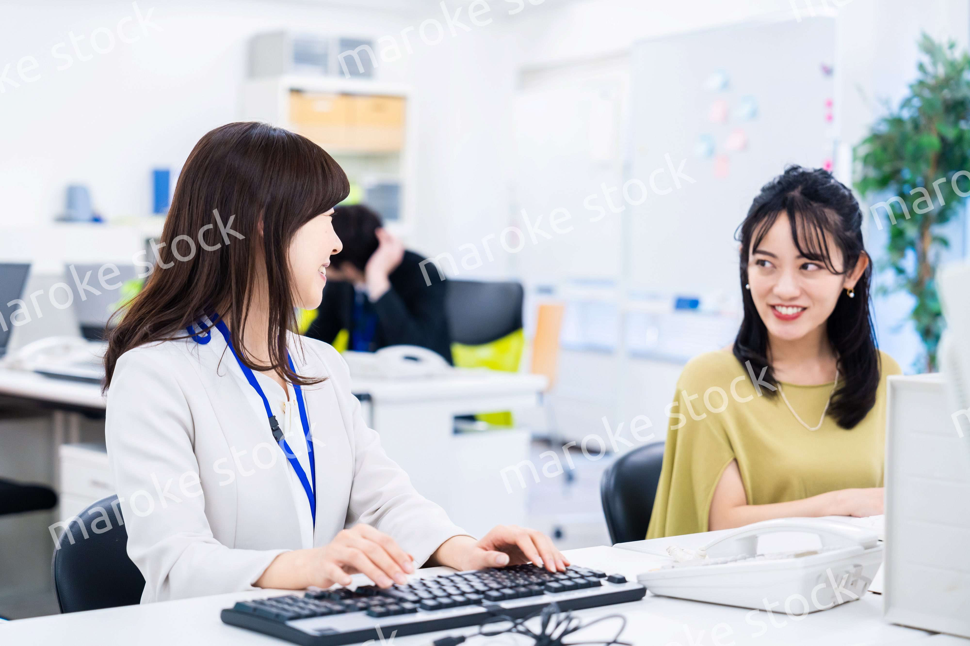 楽しく話をしながらデスクワークをする女性