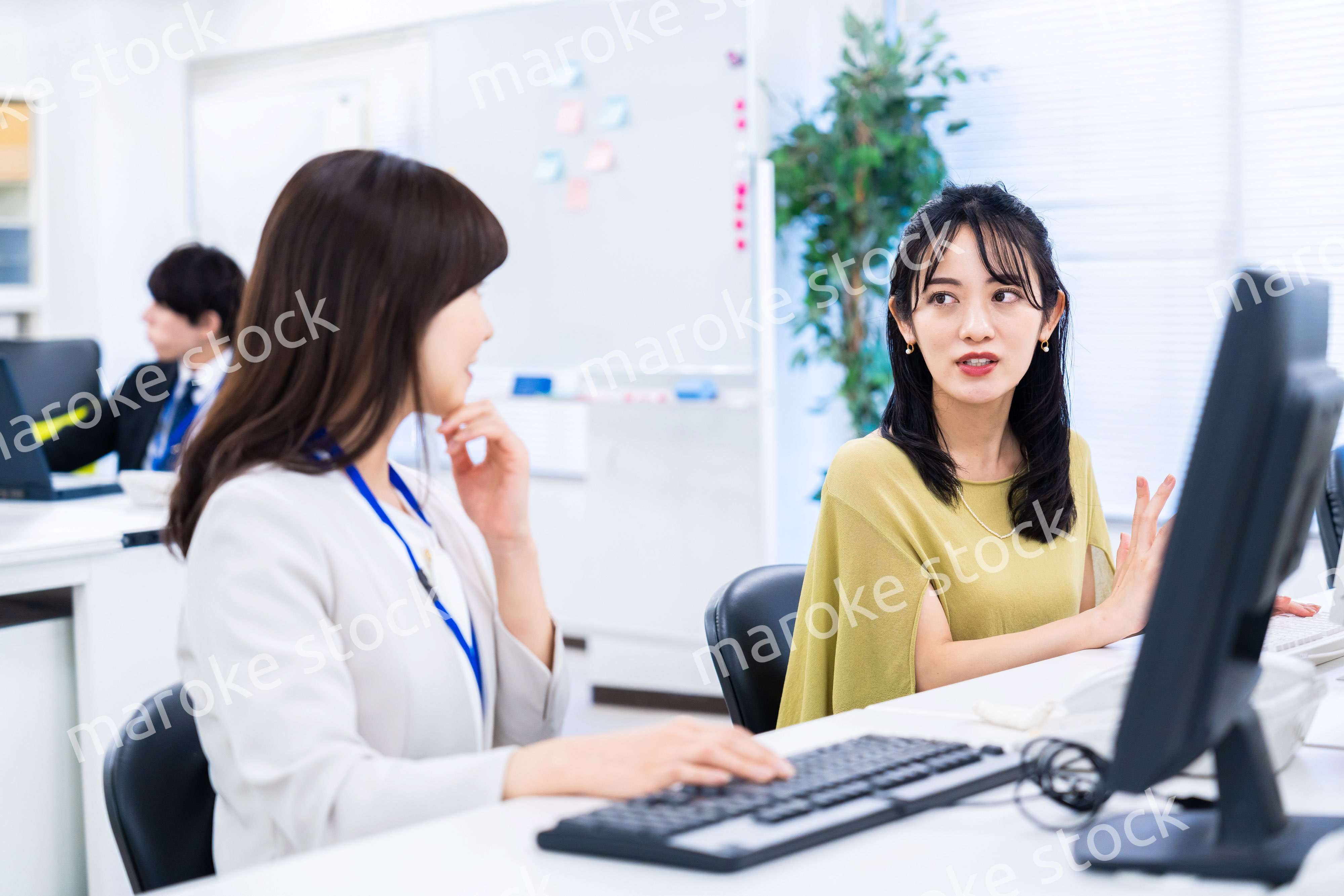 楽しく話をしながらデスクワークをする女性