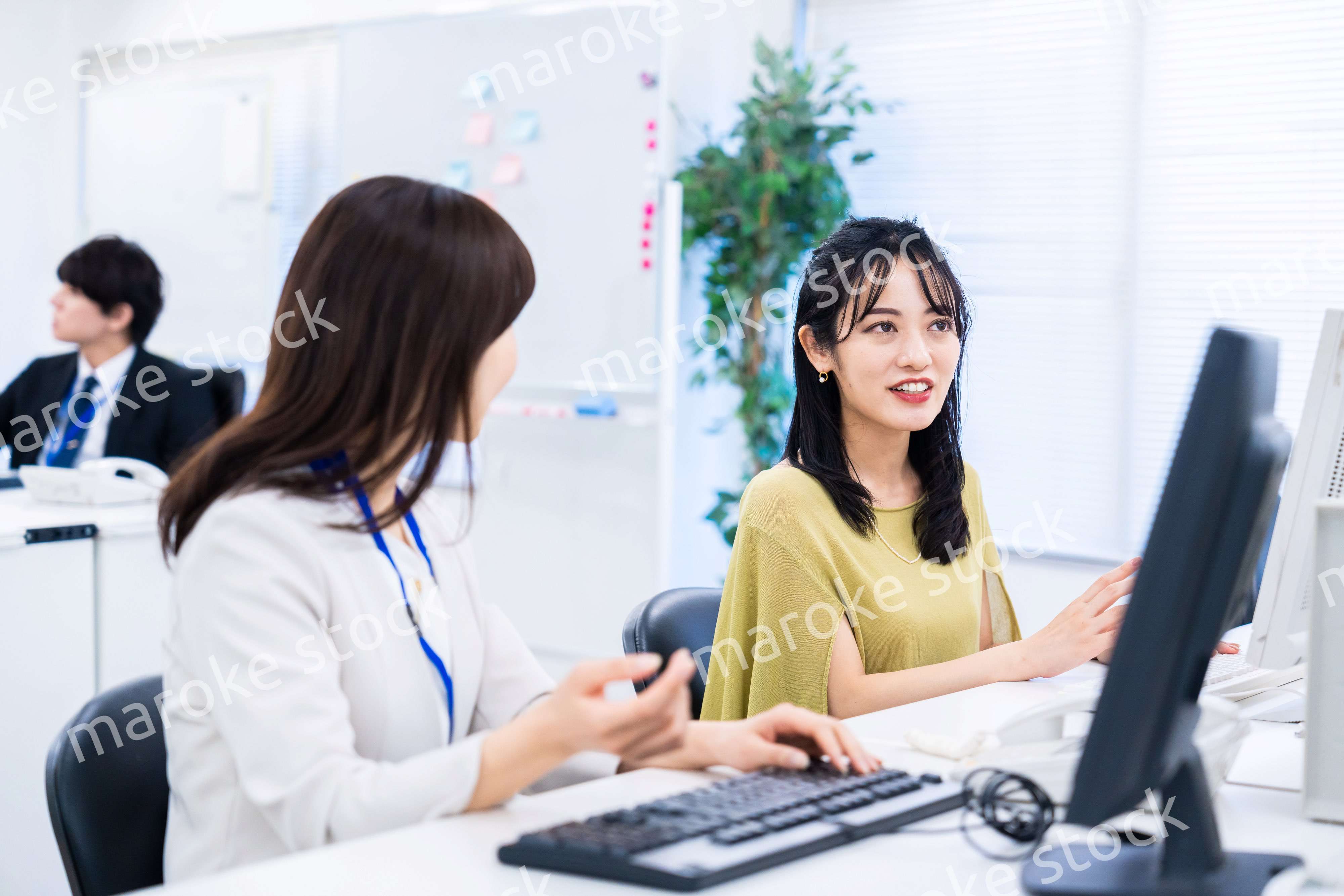 楽しく話をしながらデスクワークをする女性