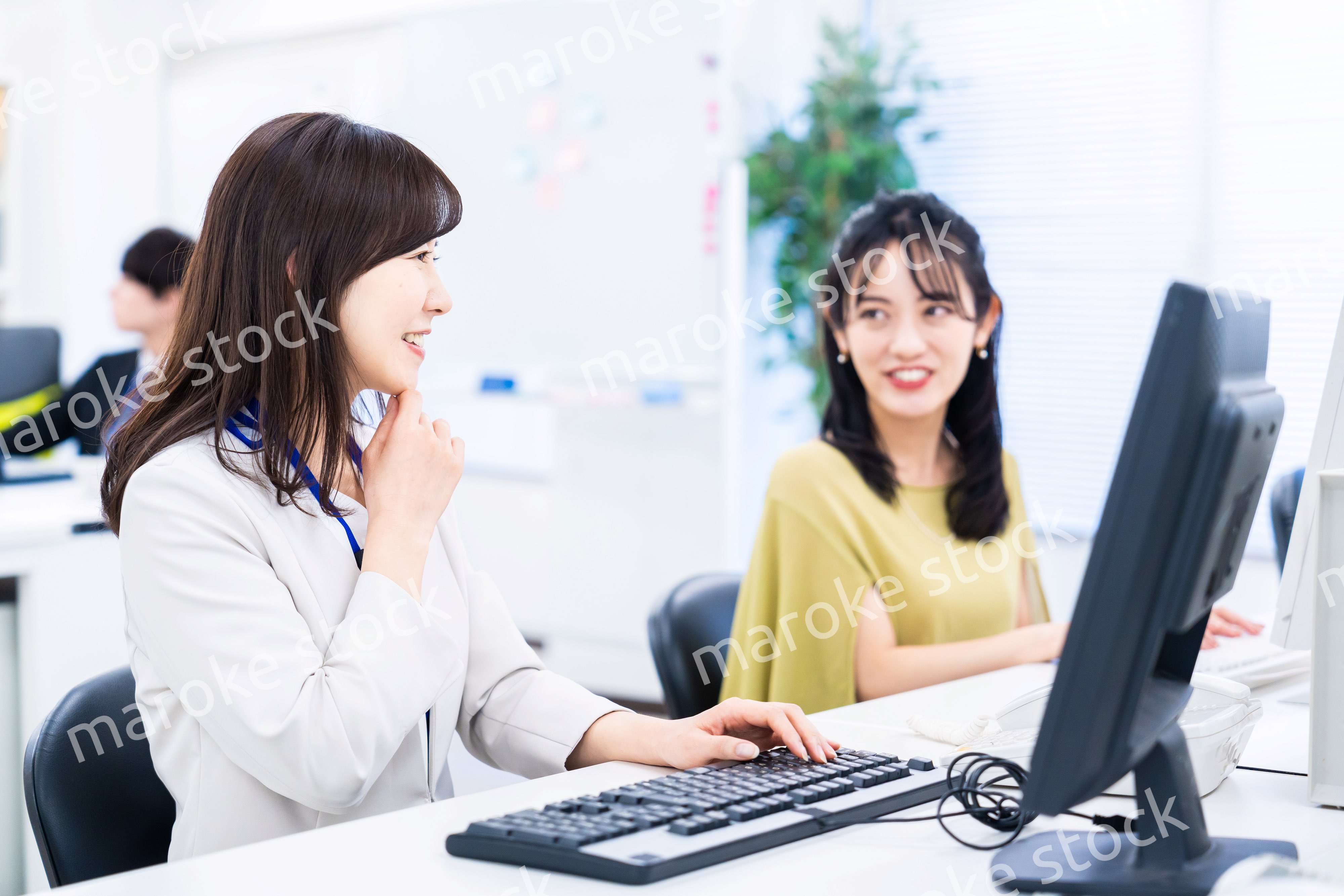 楽しく話をしながらデスクワークをする女性