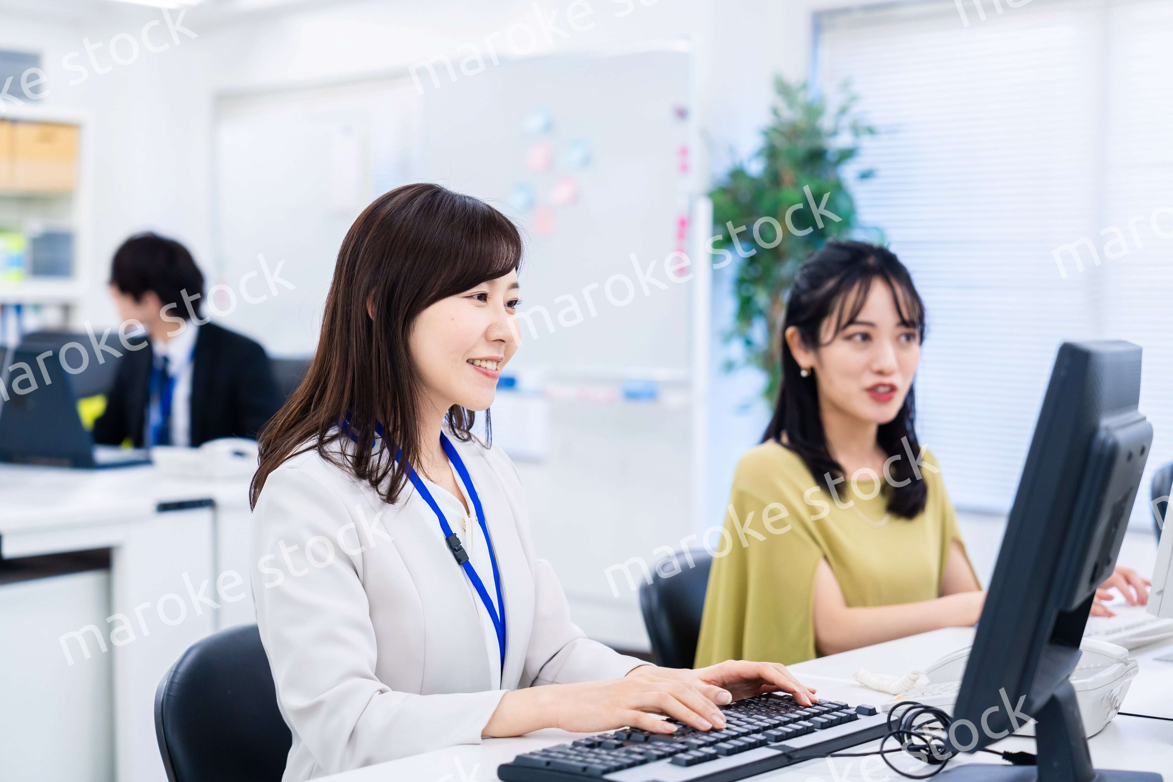 楽しく話をしながらデスクワークをする女性