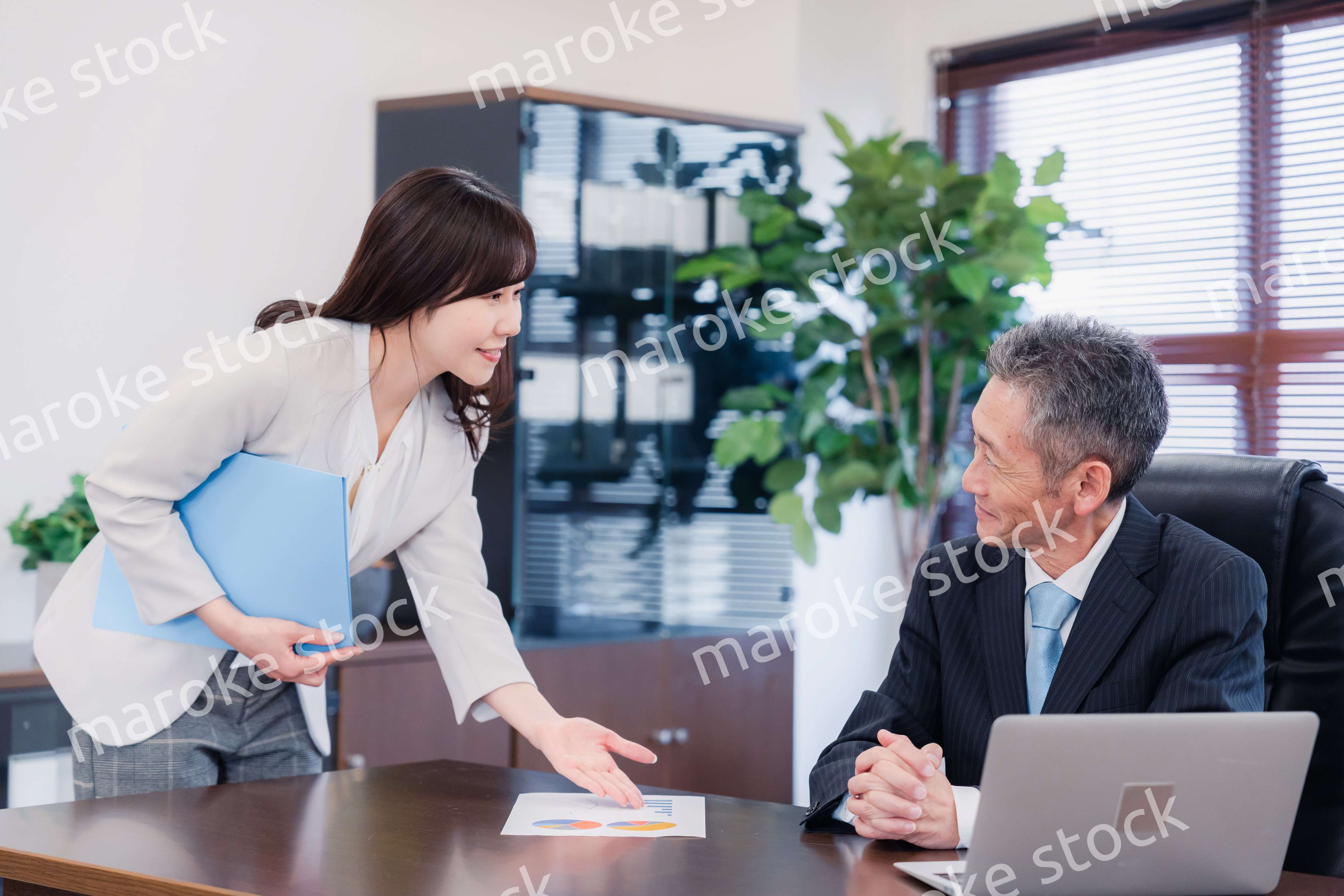 役員に報告をする秘書の女性