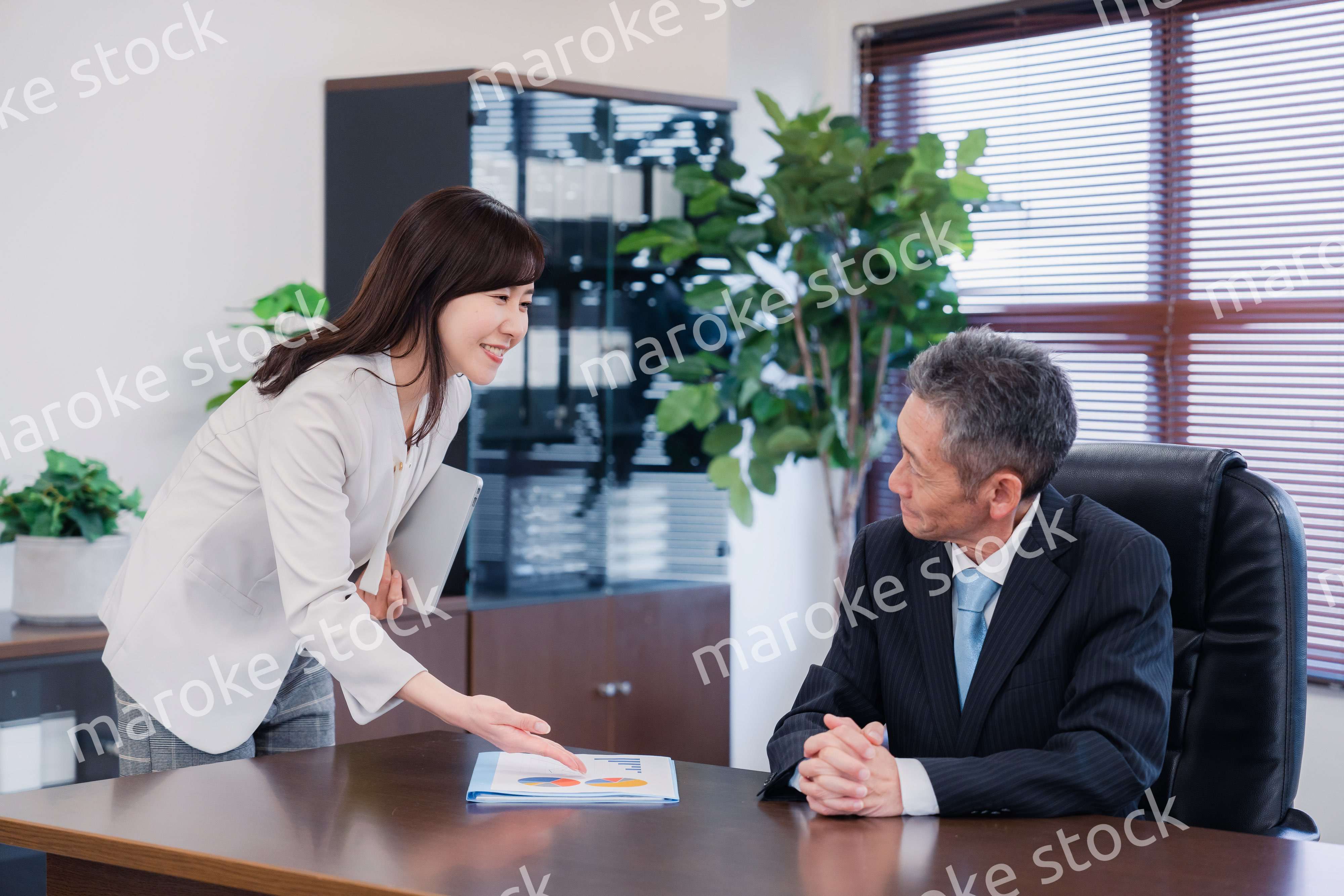 役員に報告をする秘書の女性