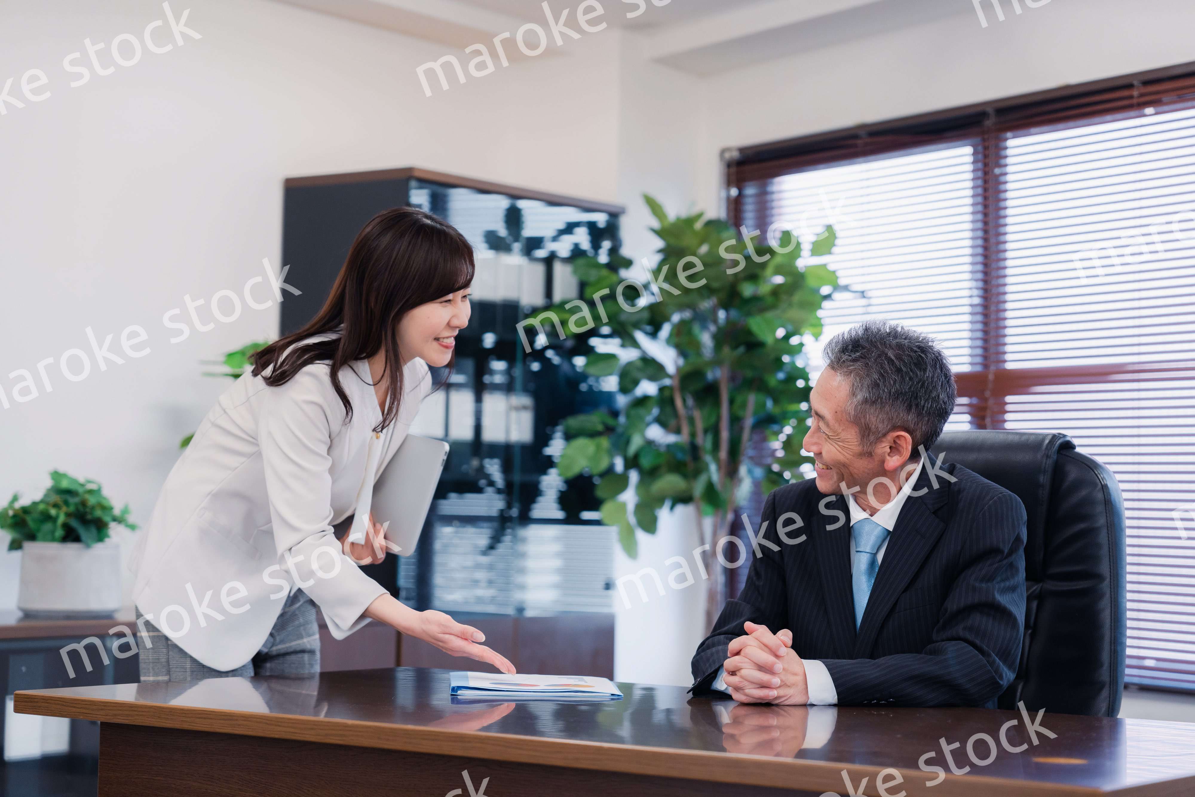 役員に報告をする秘書の女性