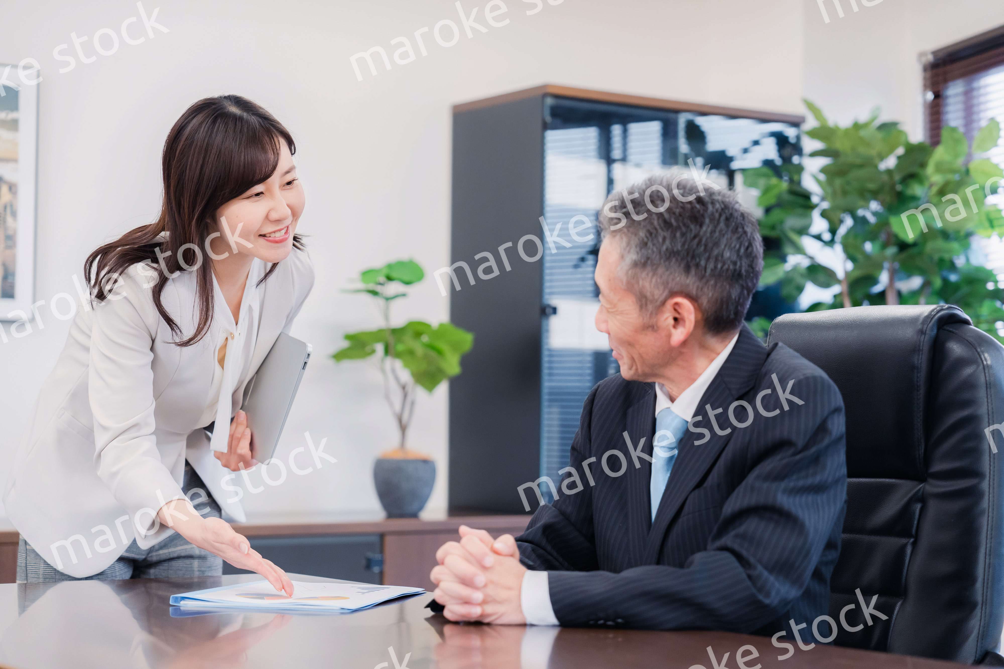 役員に報告をする秘書の女性