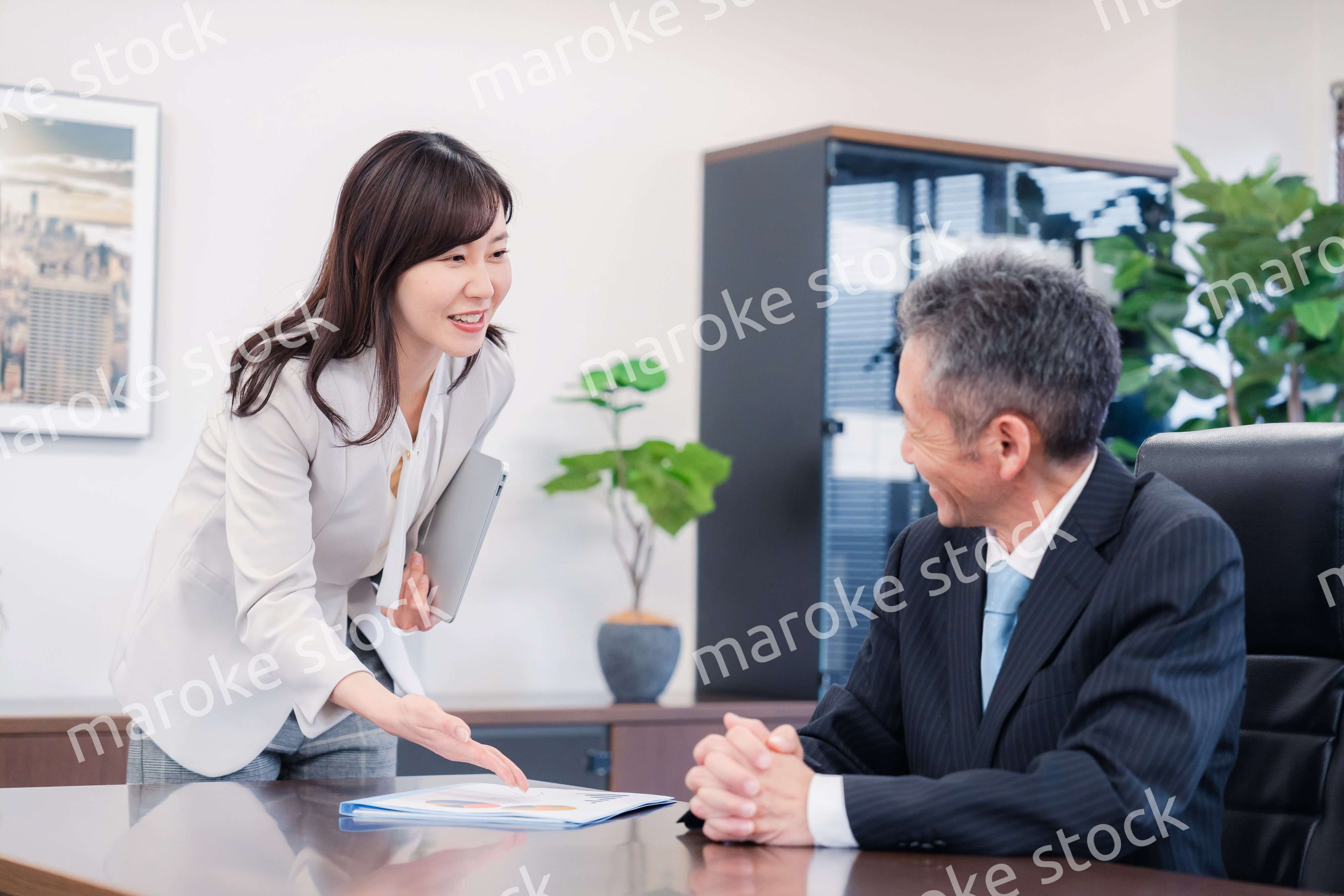 役員に報告をする秘書の女性