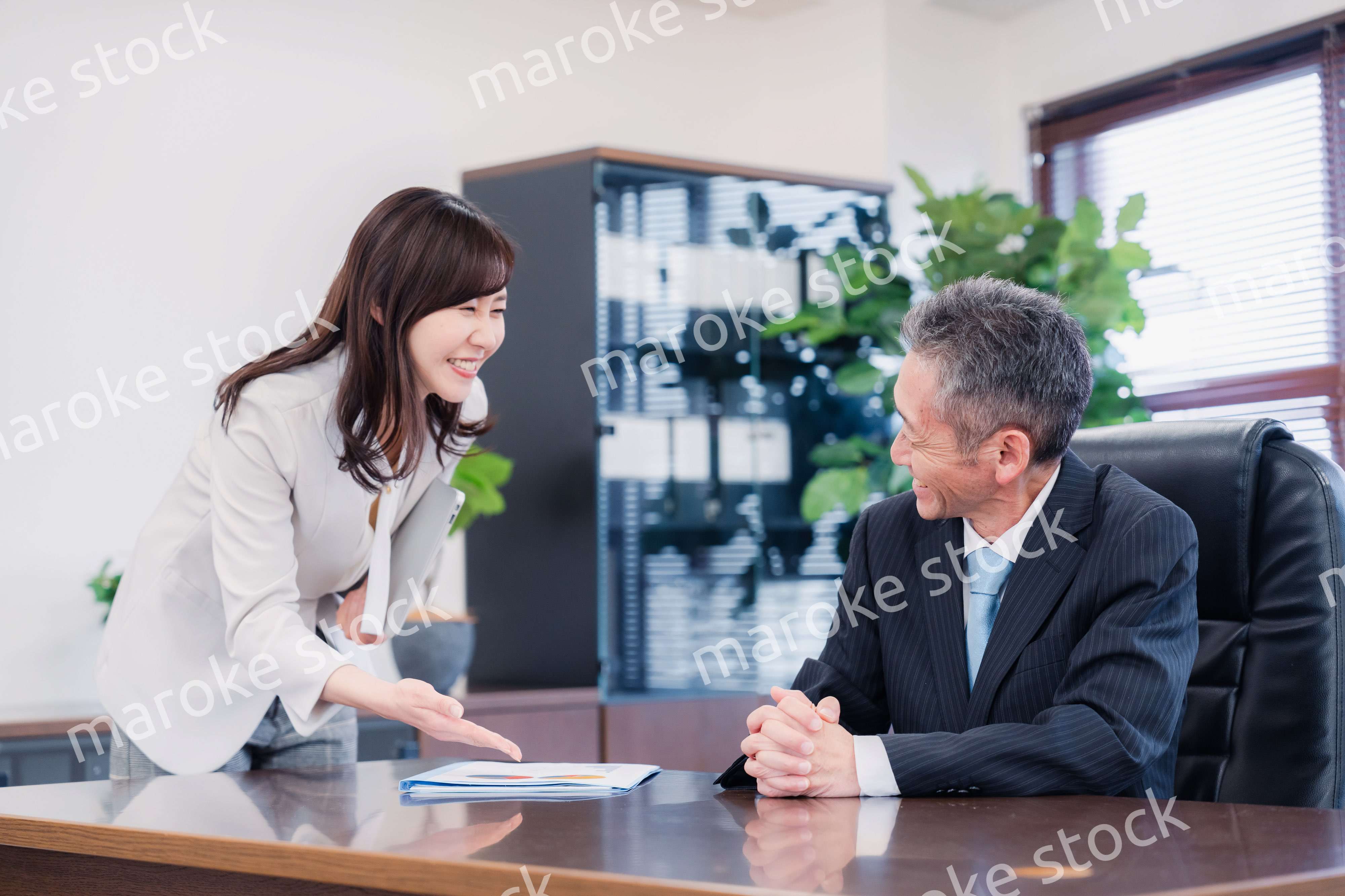 役員に報告をする秘書の女性