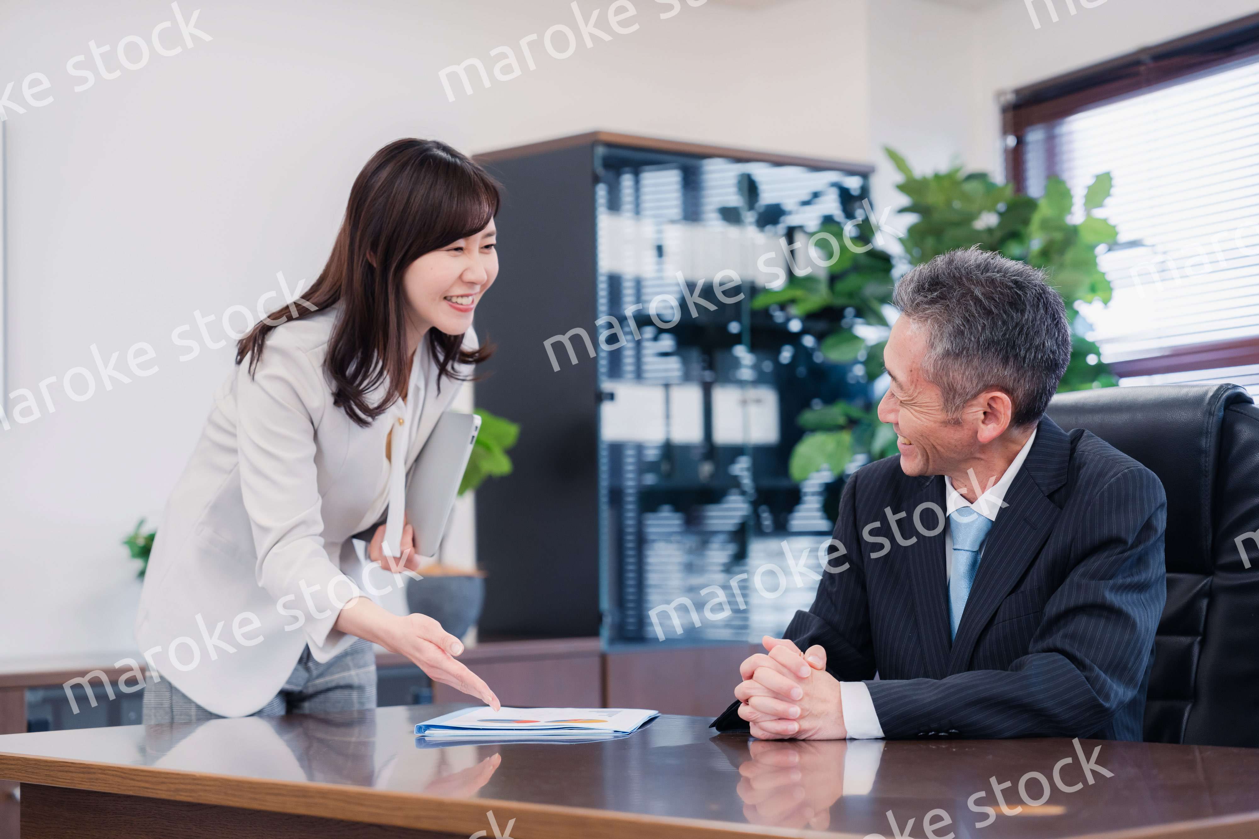 役員に報告をする秘書の女性