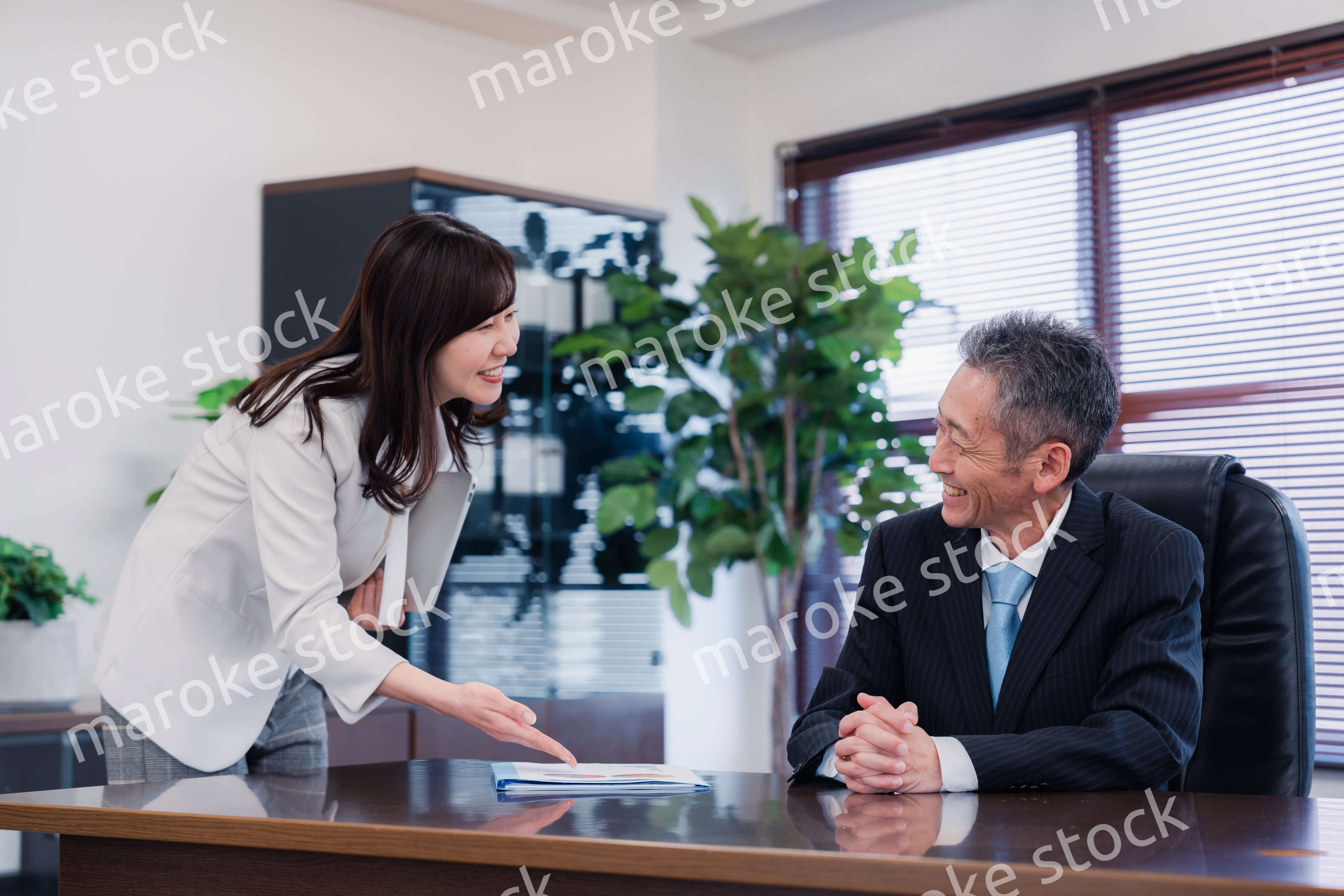 役員に報告をする秘書の女性